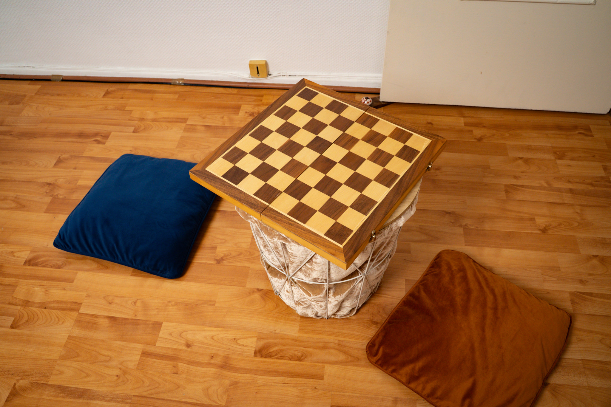 chess board on small table with two cushions on the apartment floor