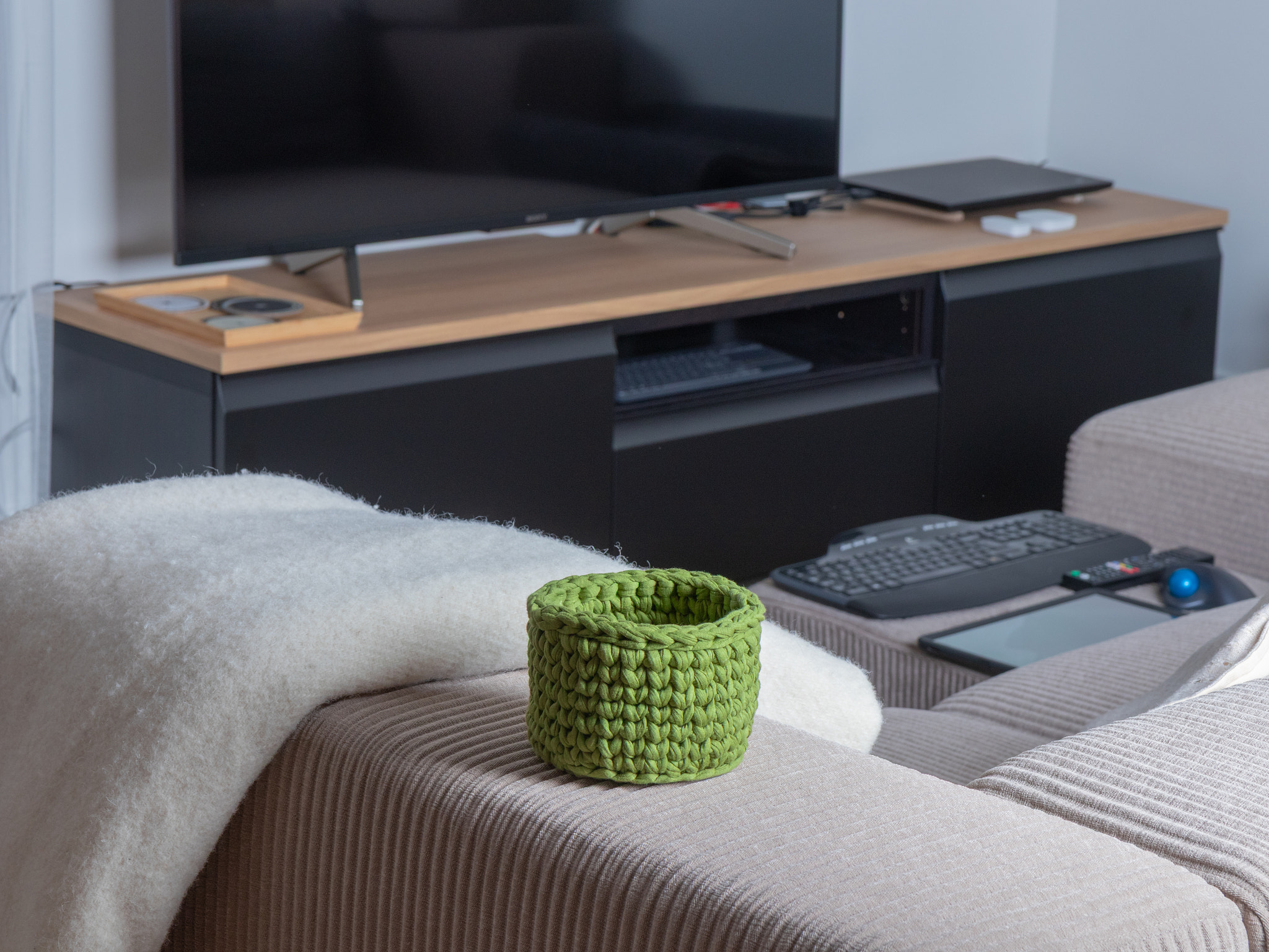 A modular sectional sofa and separate ottoman in light, wide-ribbed corduroy fabric, offering a mode