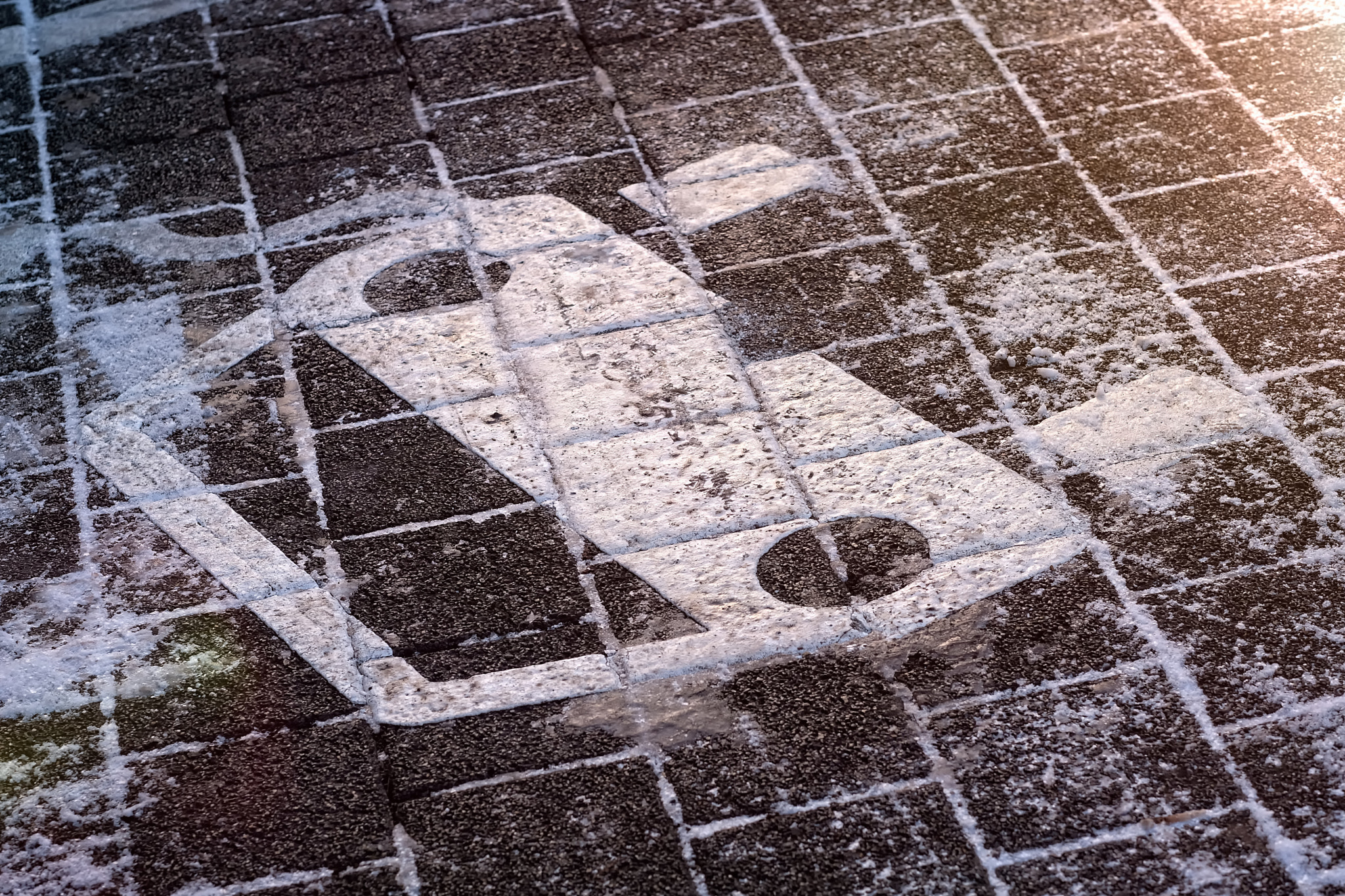 Sign at an electric vehicle parking space on snow during winter. Horizontal image.