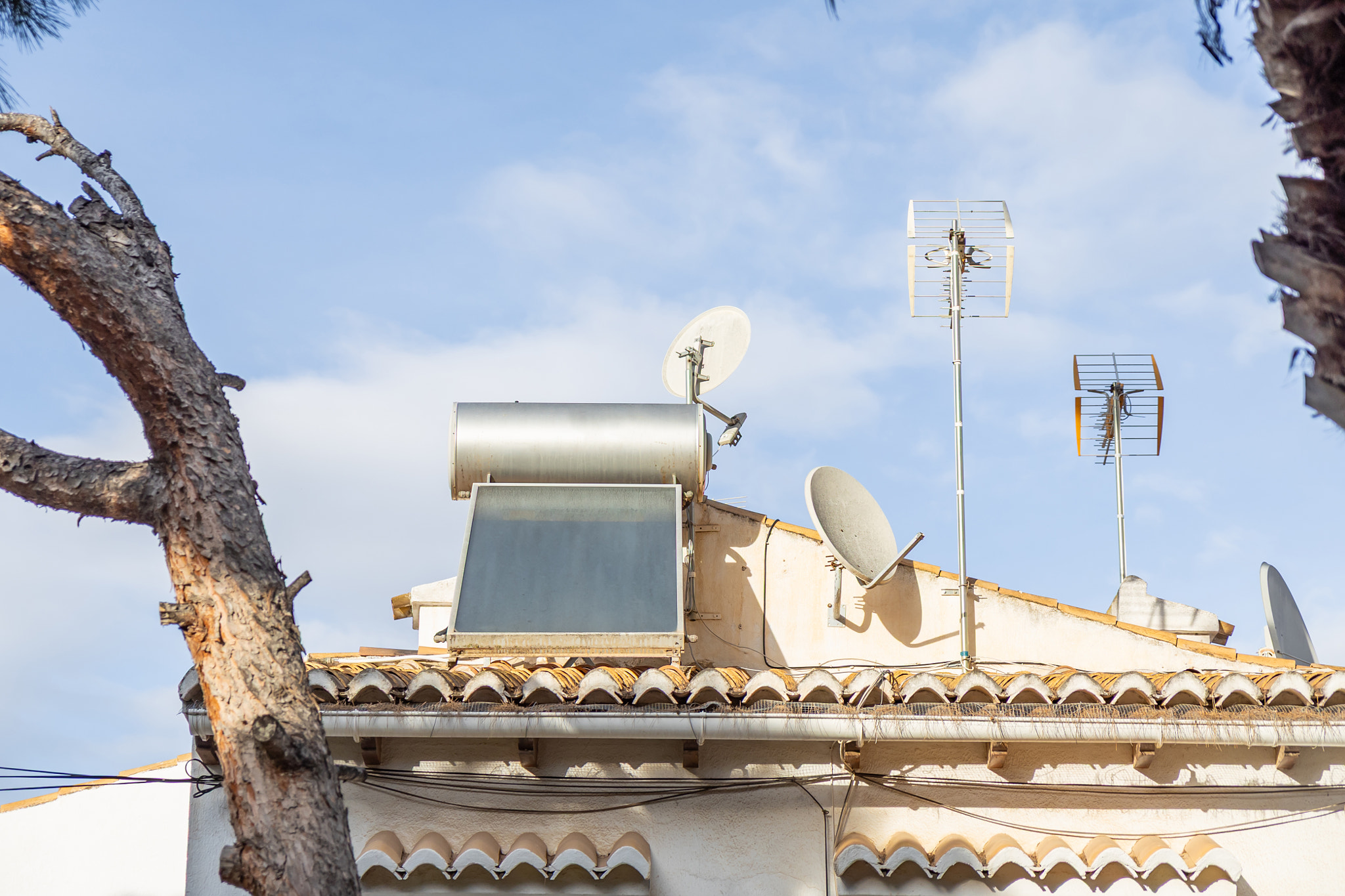 A residential rooftop equipped with a solar water heater, showcasing sustainable home technology des