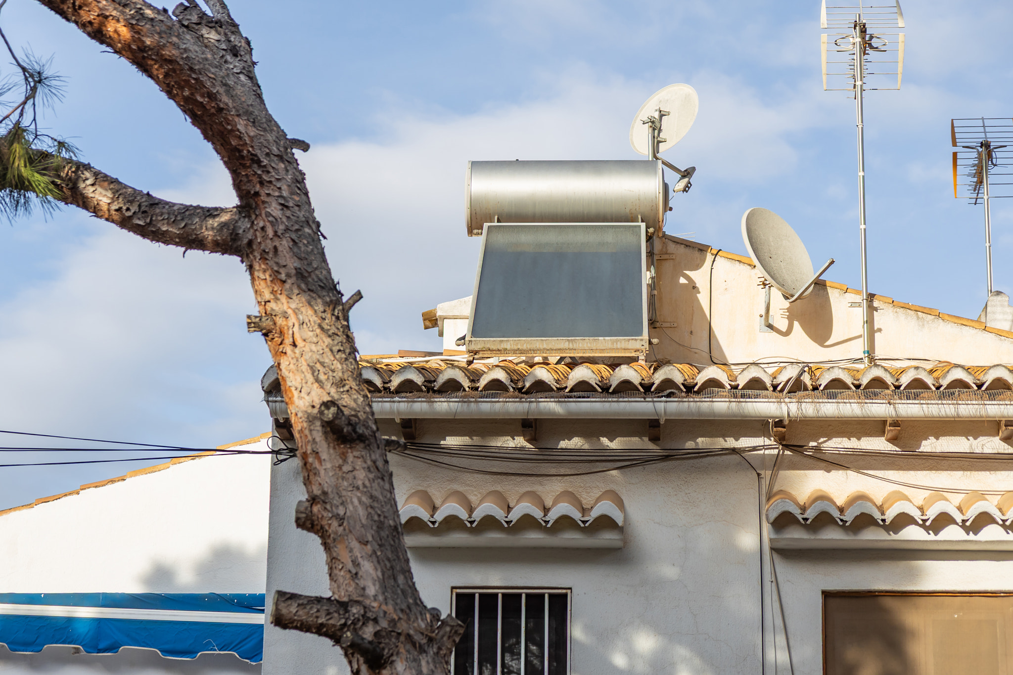 A residential rooftop equipped with a solar water heater, showcasing sustainable home technology des