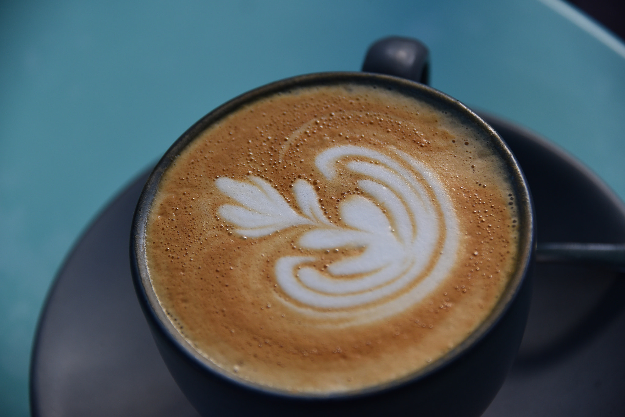 Large format high angle view of cappuccino with foam art on table