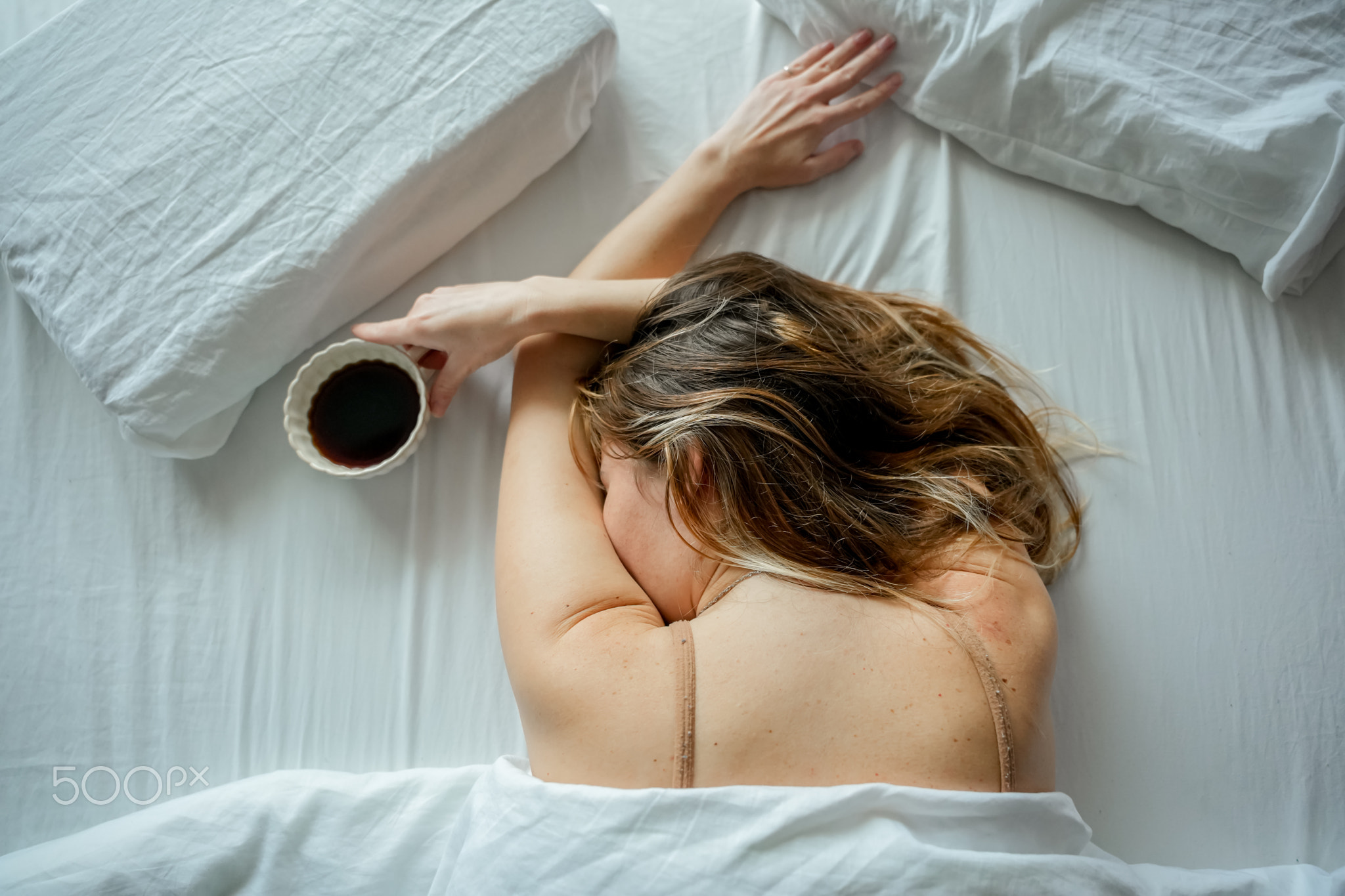Woman Lying Face Down Holding Coffee