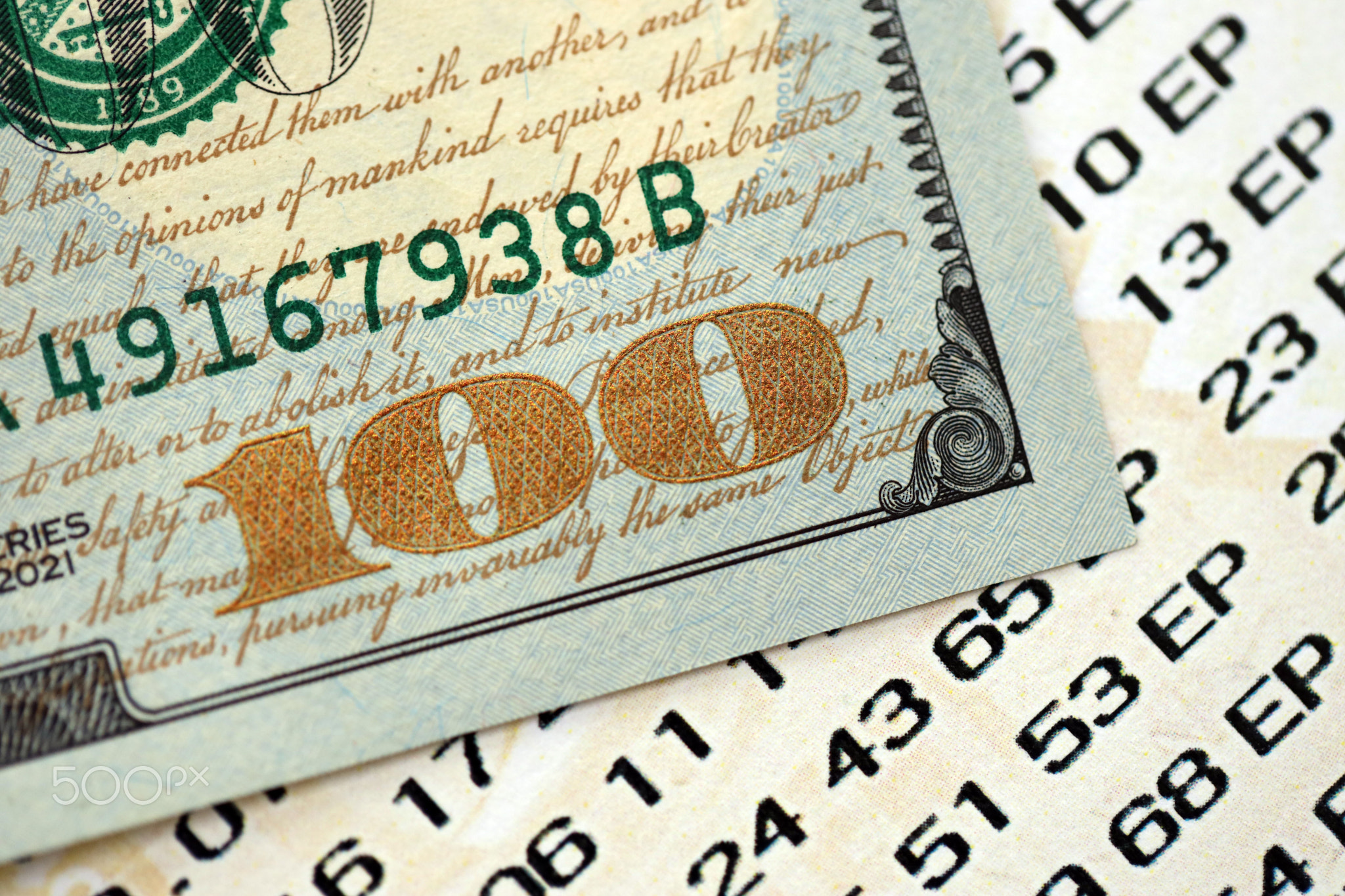 Lottery ticket and one hundred US dollar bill close up. Concept of gambling addiction