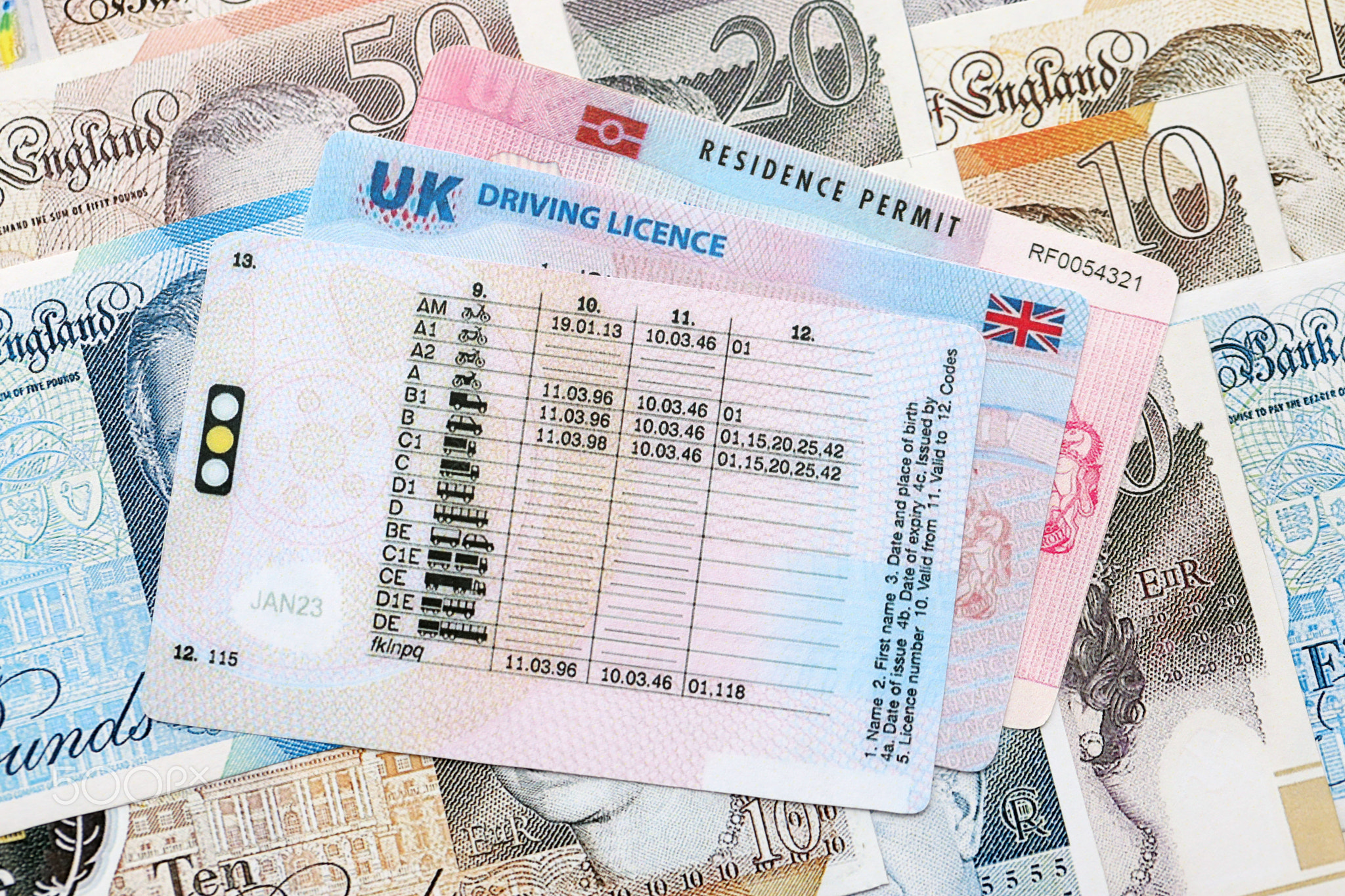 United Kingdom driving license with residence permit card on UK money