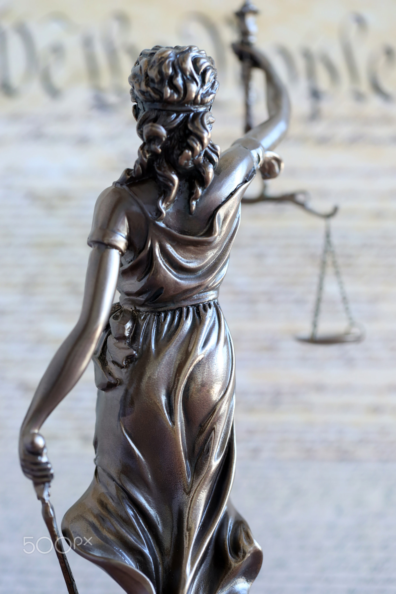 Lady Justice old statue and US Constitution blurred page close up. Lawsuit and justice in US