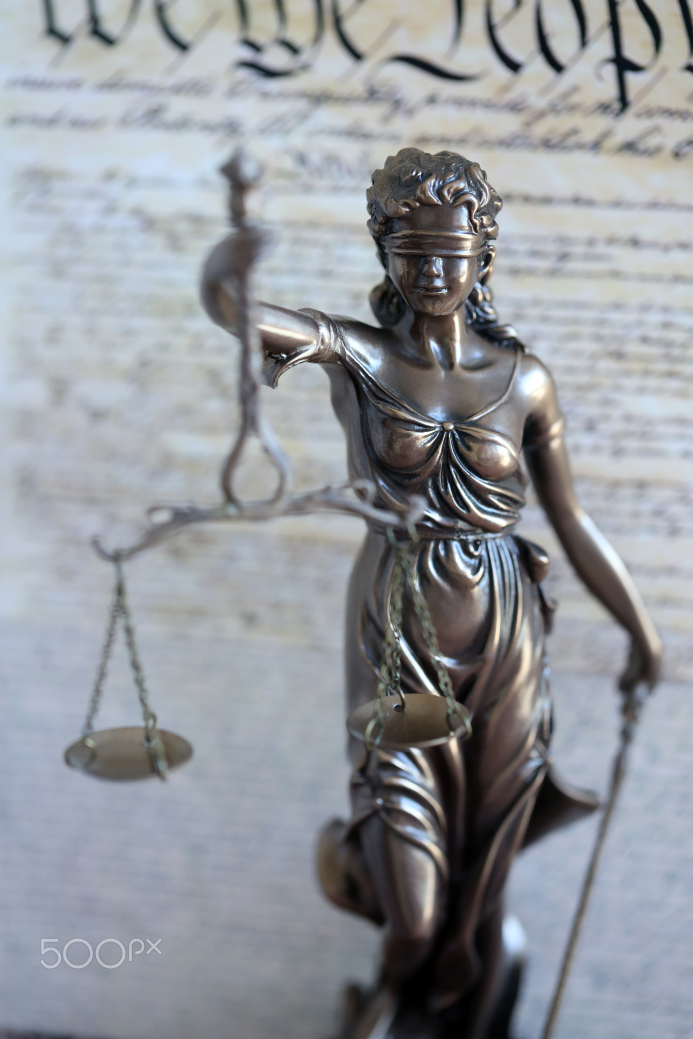 The statue of justice Themis or Justitia, the blindfolded goddess of justice against US Constitution