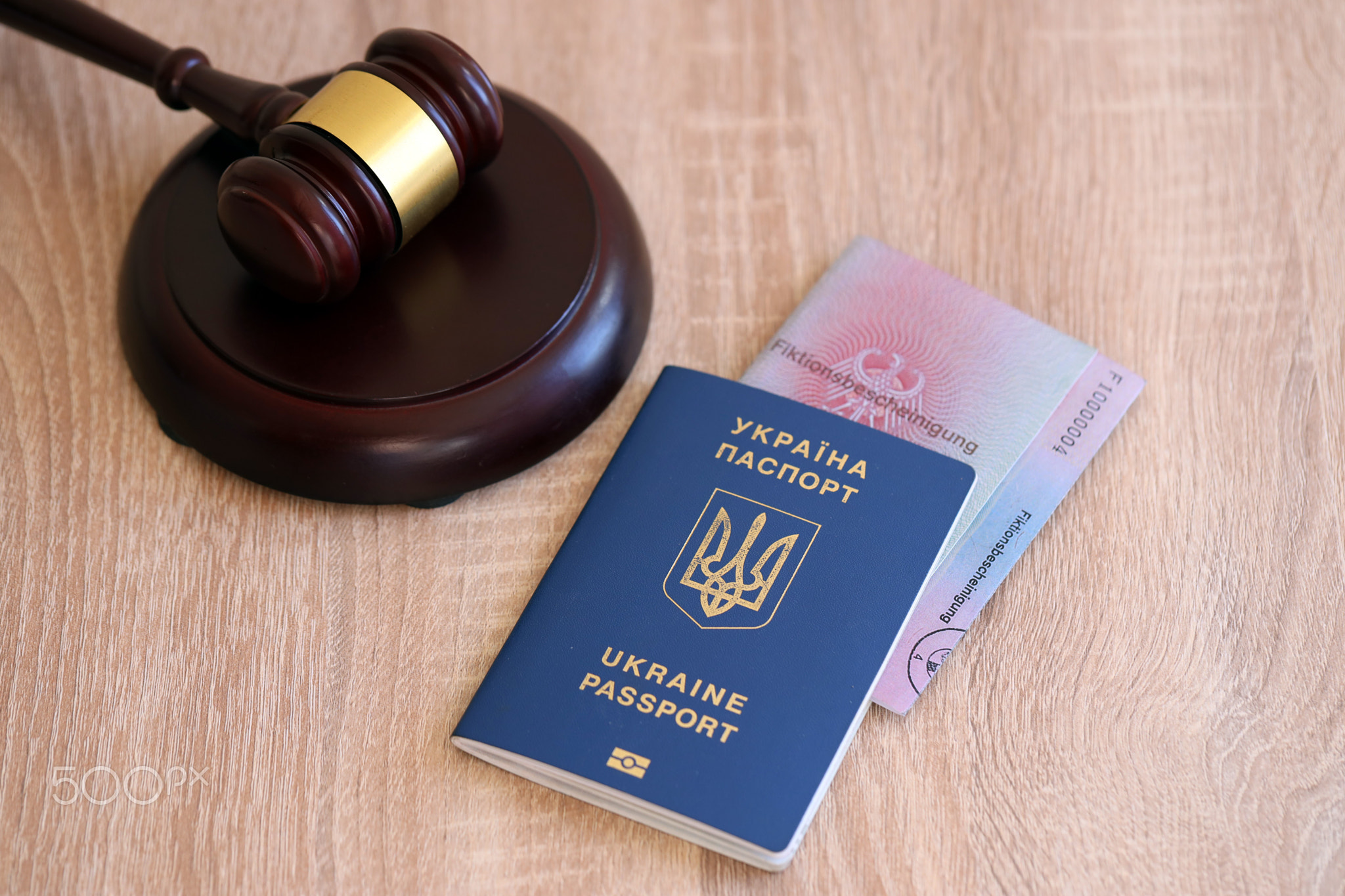 German temporary Permanent resident card and Ukrainian passport lies with judge hammer