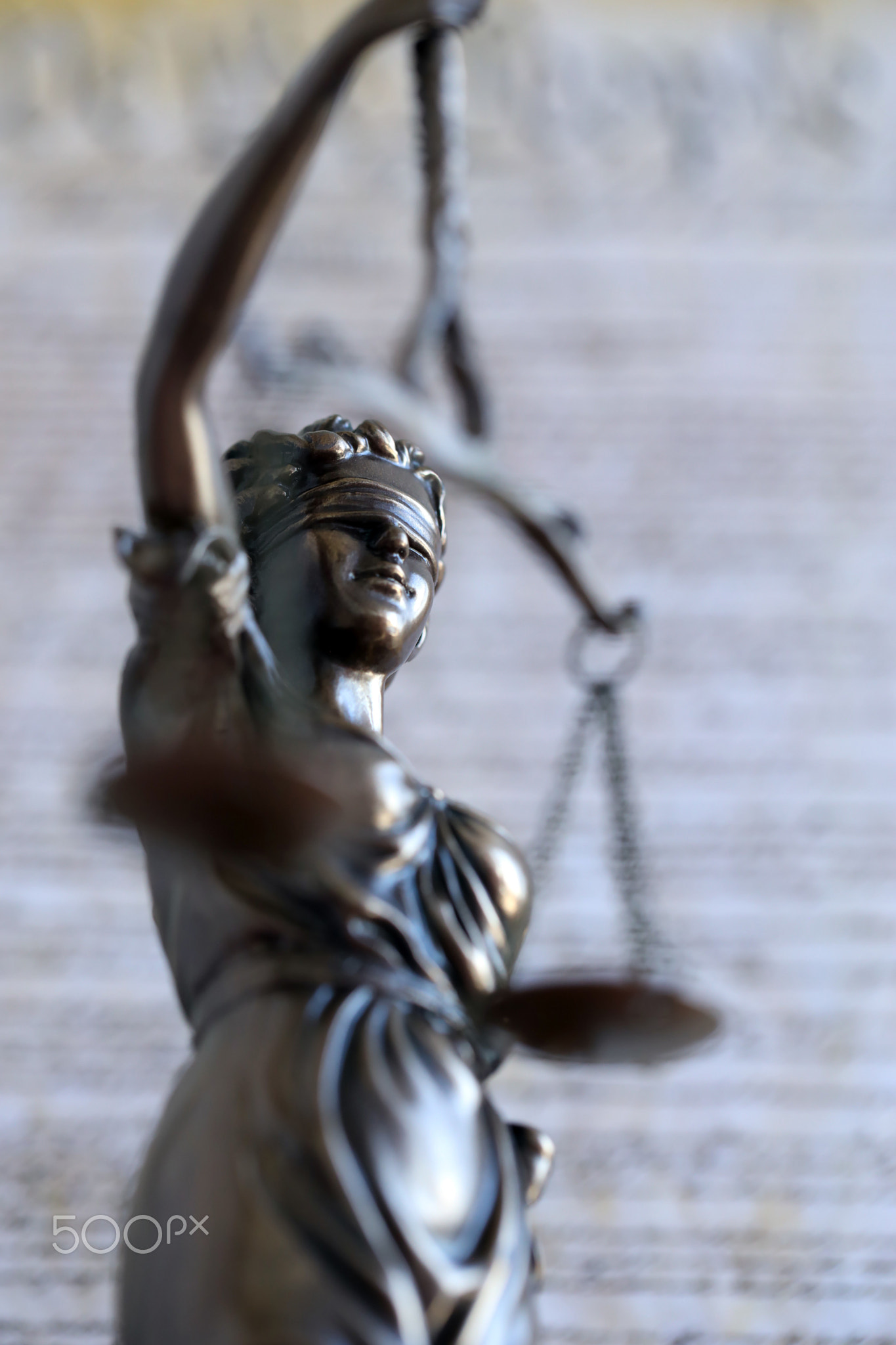 Lady Justice old statue and US Constitution blurred page close up. Lawsuit and justice in US