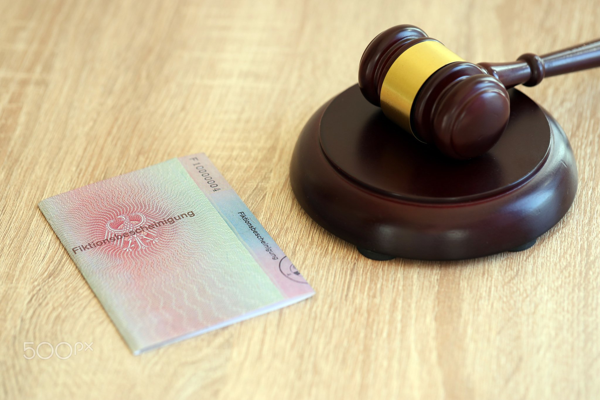 German temporary Permanent resident card specimen lies with judge hammer. Fiktionsbescheinigung