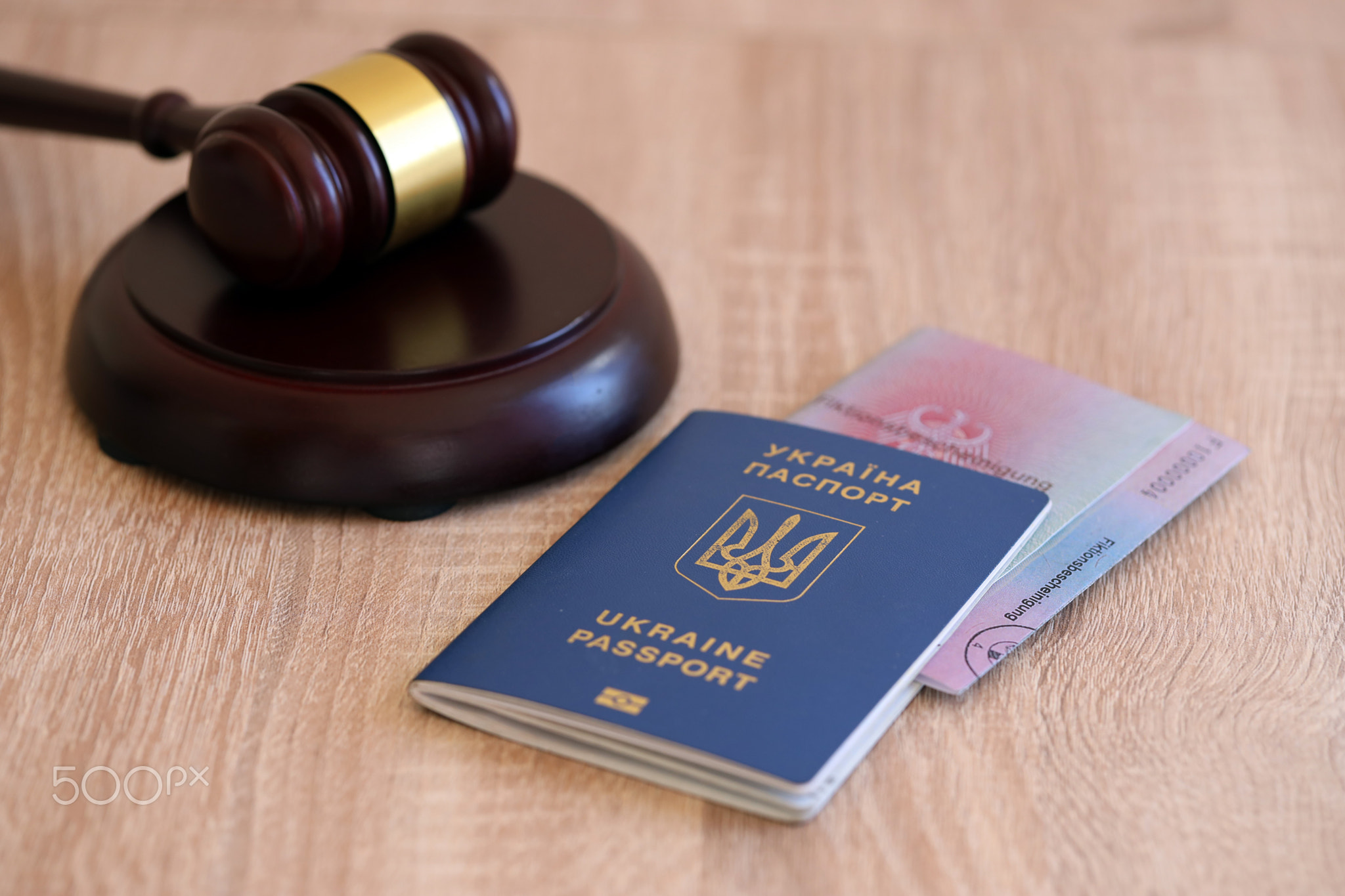 German temporary Permanent resident card and Ukrainian passport lies with judge hammer