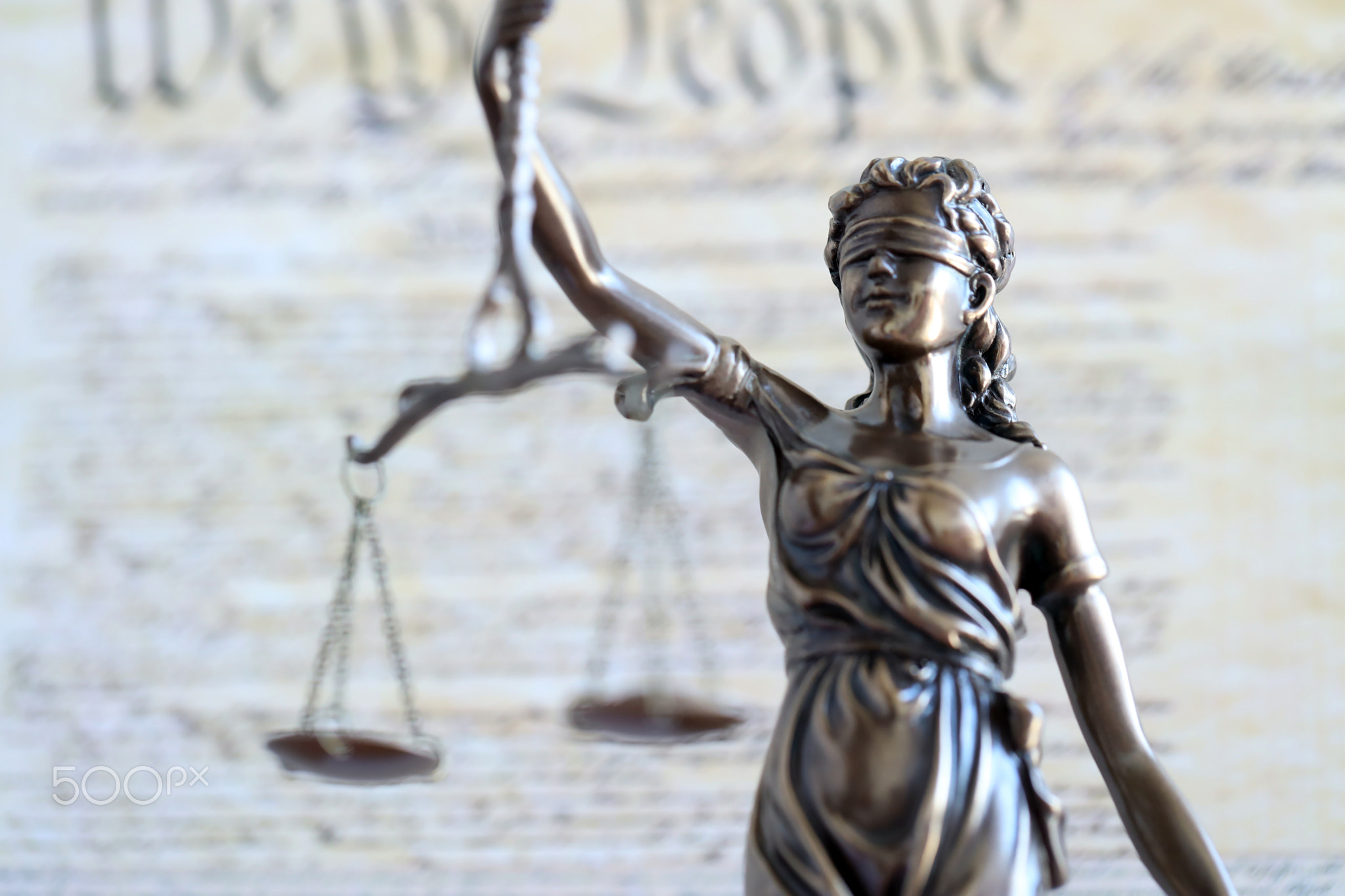 The statue of justice Themis or Justitia, the blindfolded goddess of justice against US Constitution