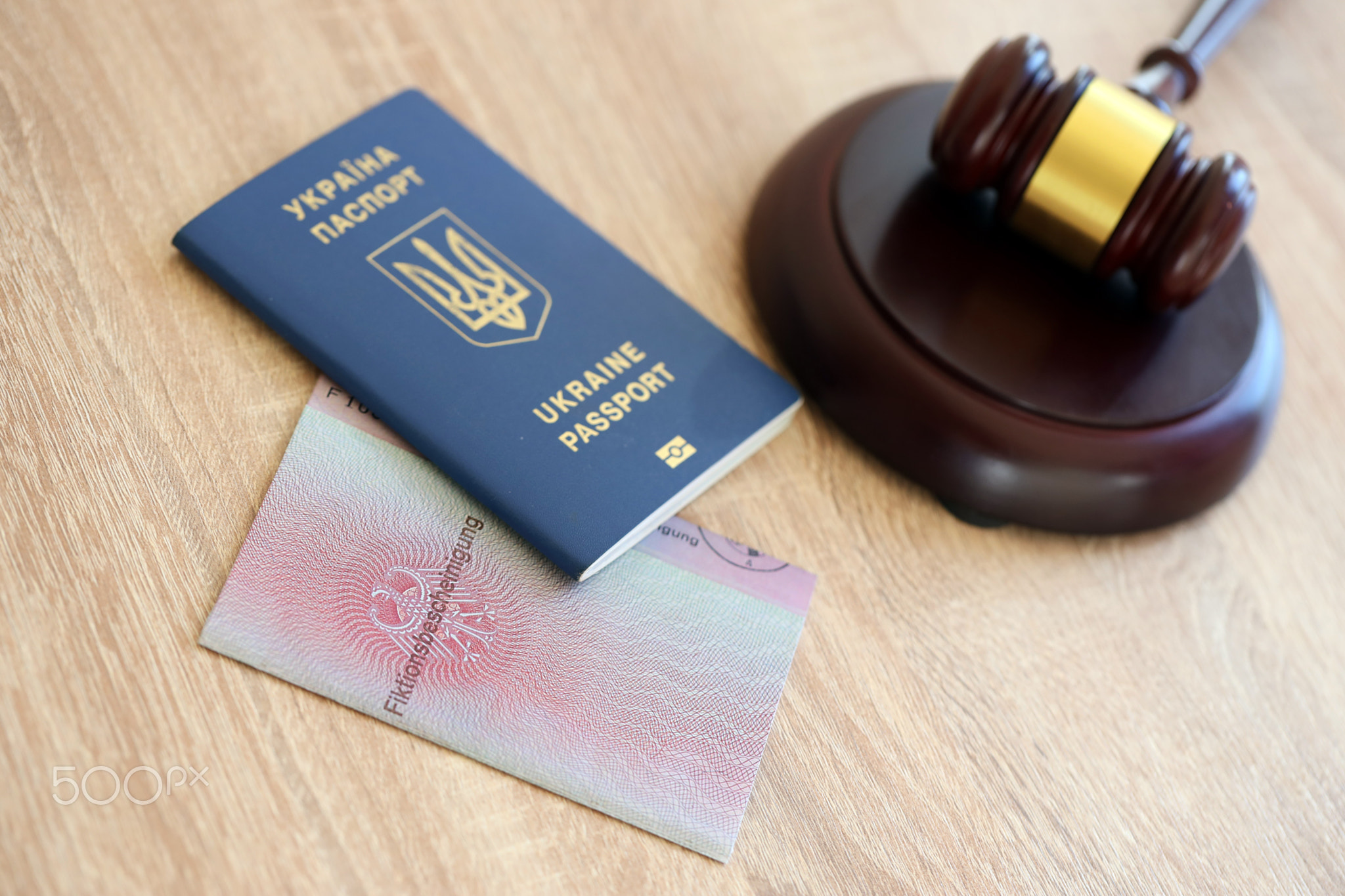 German temporary Permanent resident card and Ukrainian passport lies with judge hammer