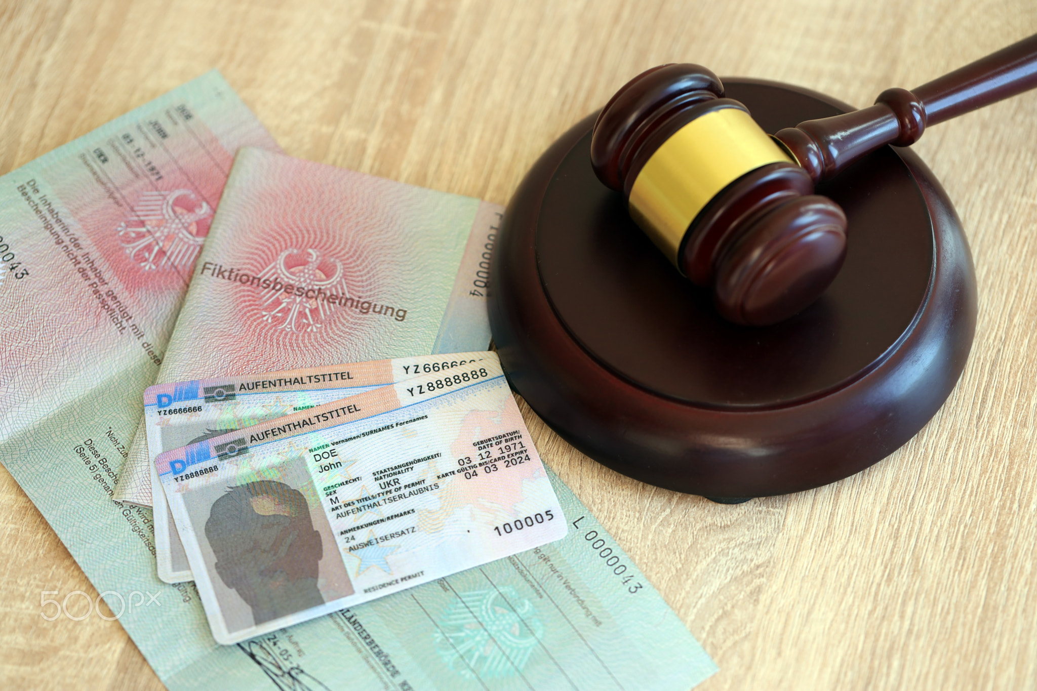 German temporary Permanent resident card lies with judge hammer. Aufenthaltstitel
