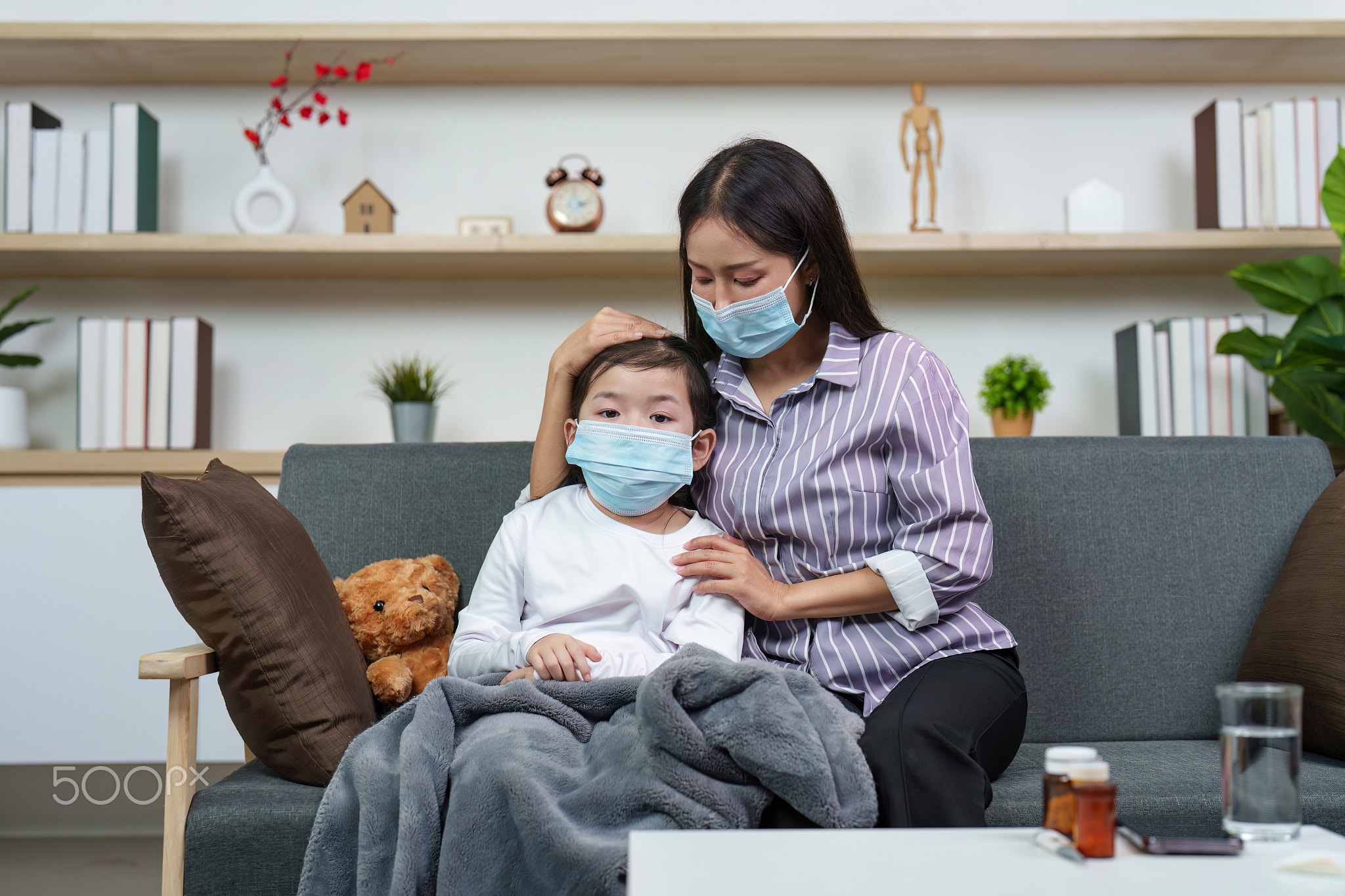 Mother and son wearing masks, sharing a caring moment