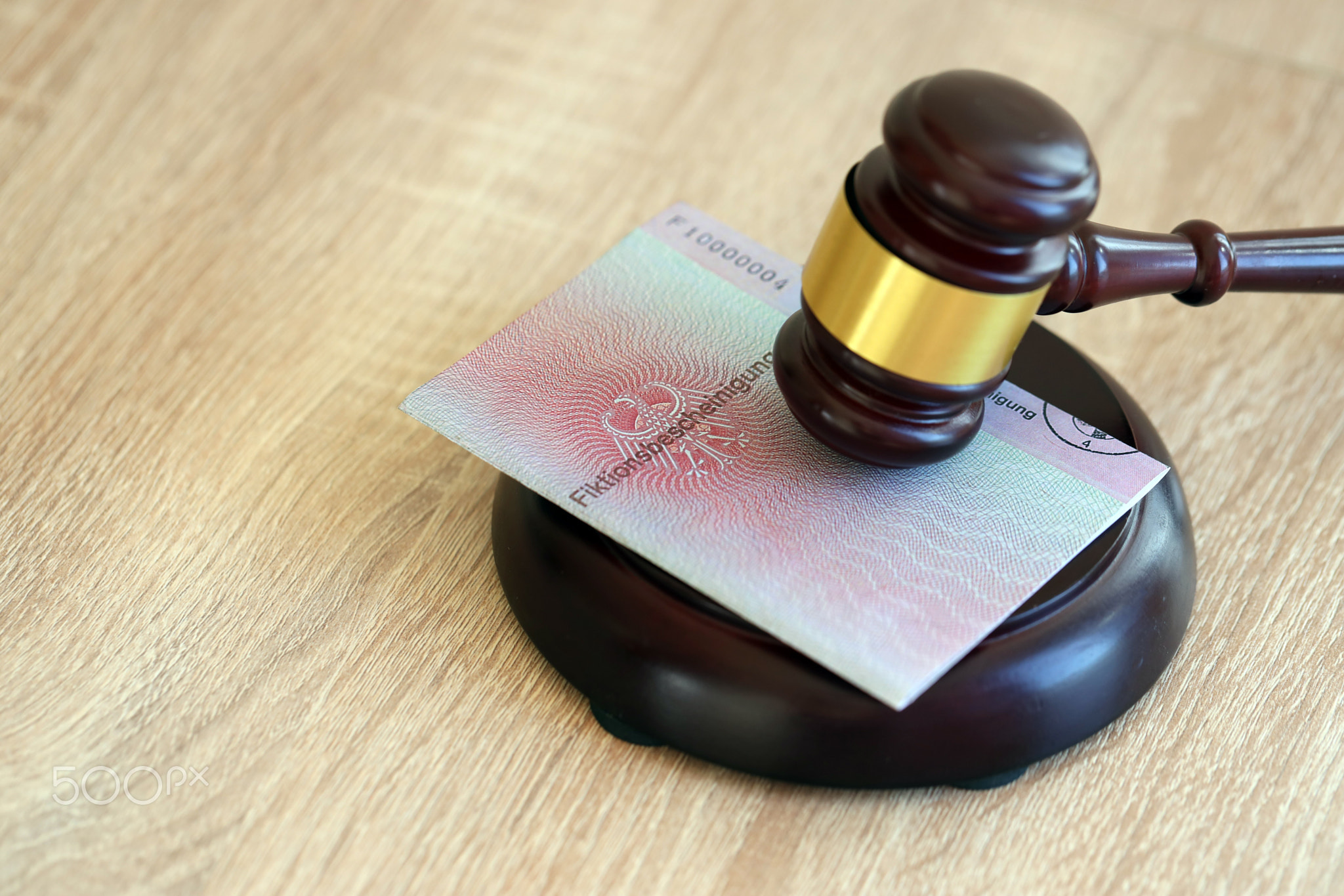 German temporary Permanent resident card specimen lies with judge hammer. Fiktionsbescheinigung