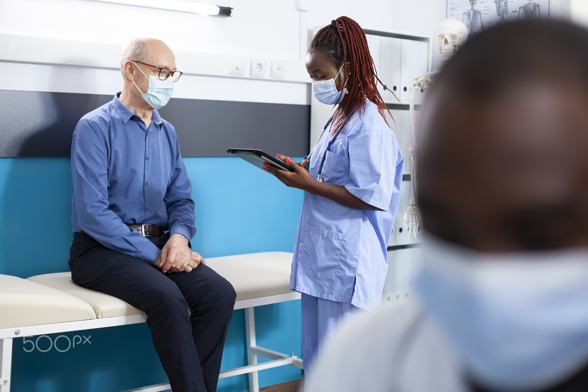 Nurse consults with old man using tablet