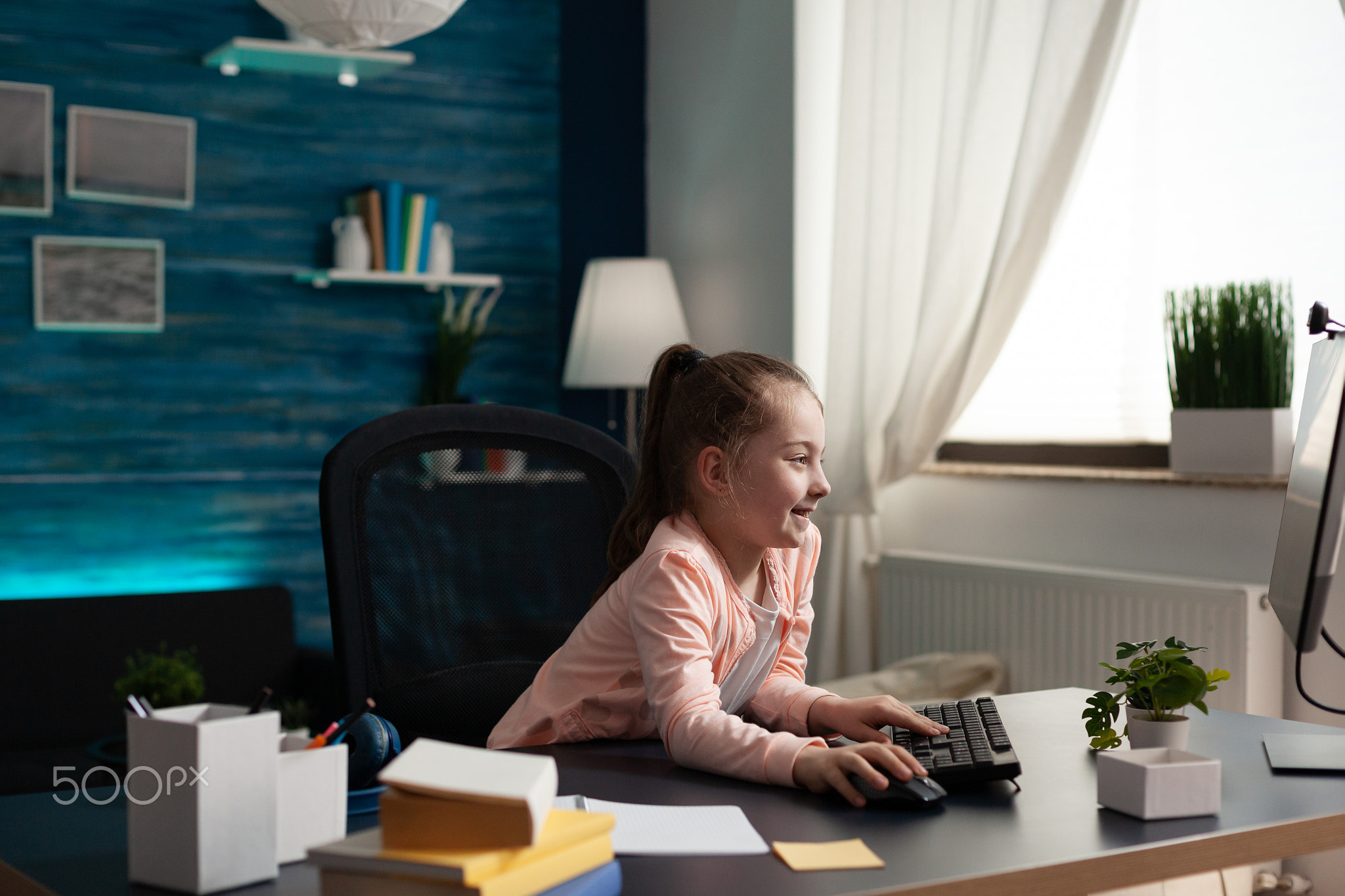 Smart little pupil looking at computer monitor screen