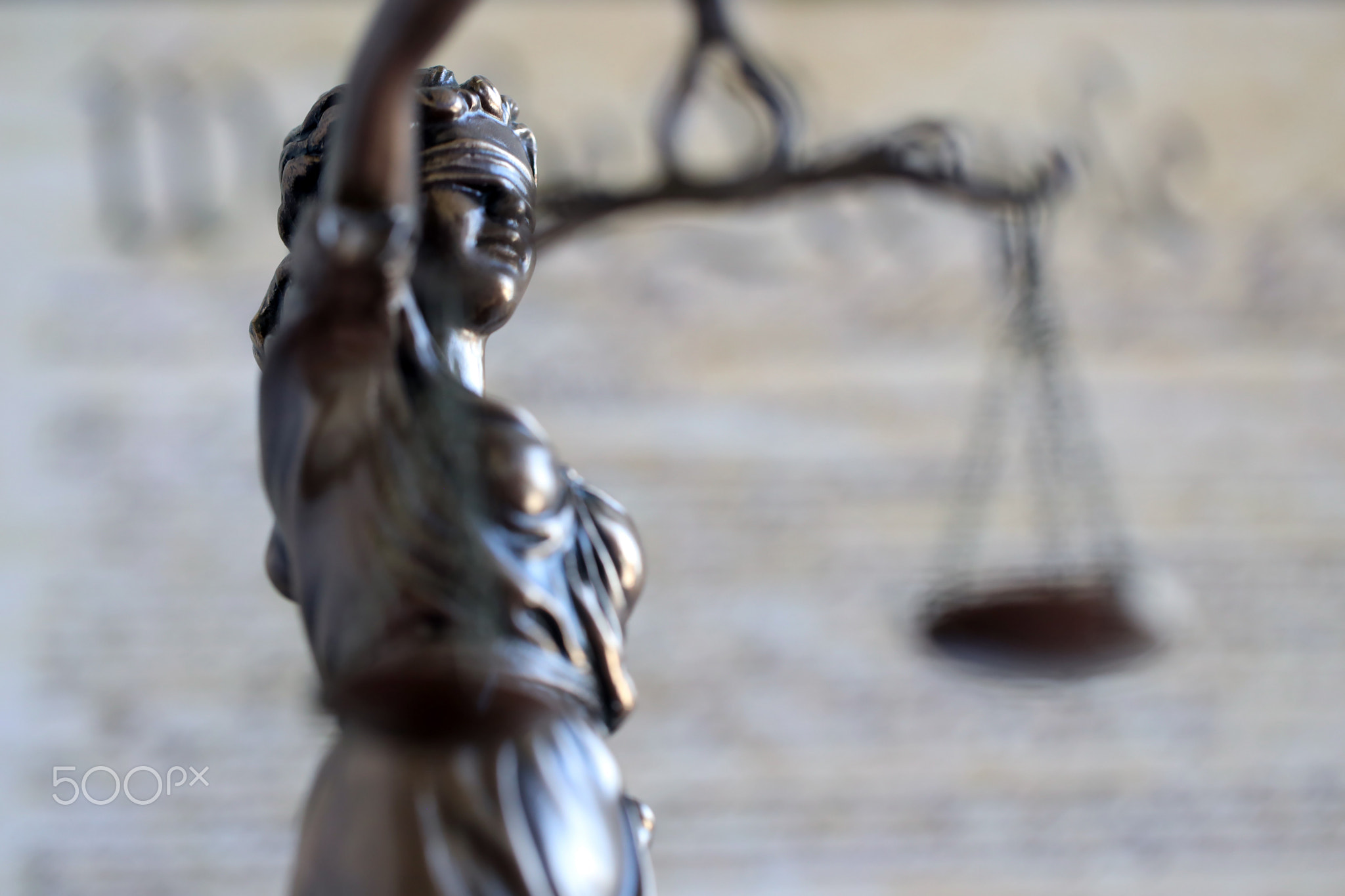 Lady Justice statue with scales on background of US Constitution. Lawsuit and punishment in US