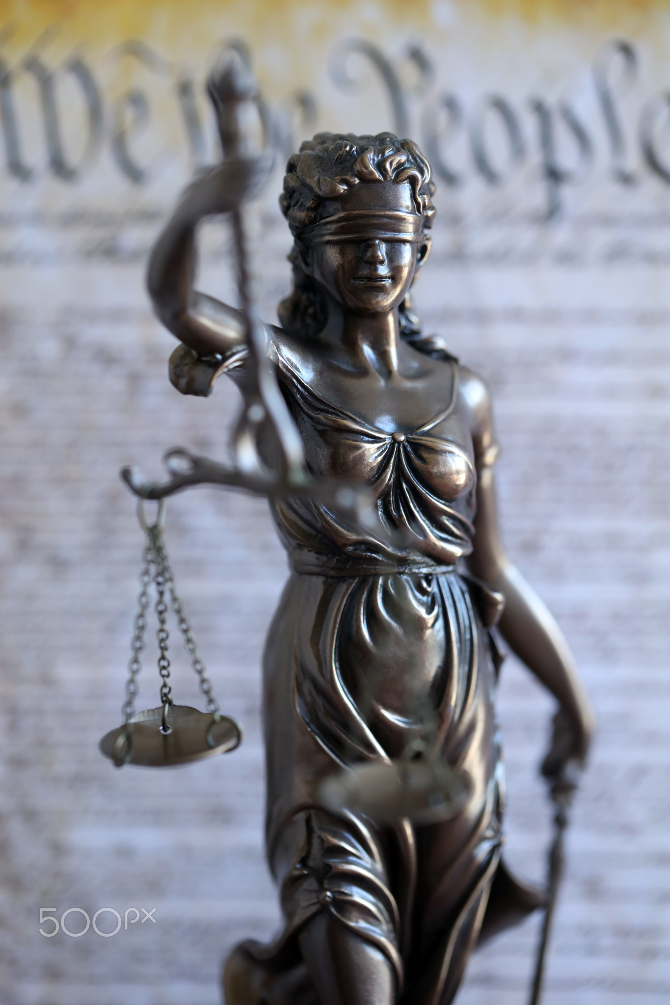 The statue of justice Themis or Justitia, the blindfolded goddess of justice against US Constitution
