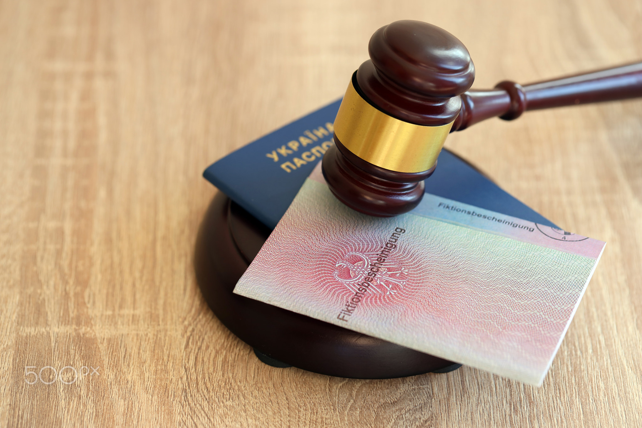 German temporary Permanent resident card and Ukrainian passport lies with judge hammer