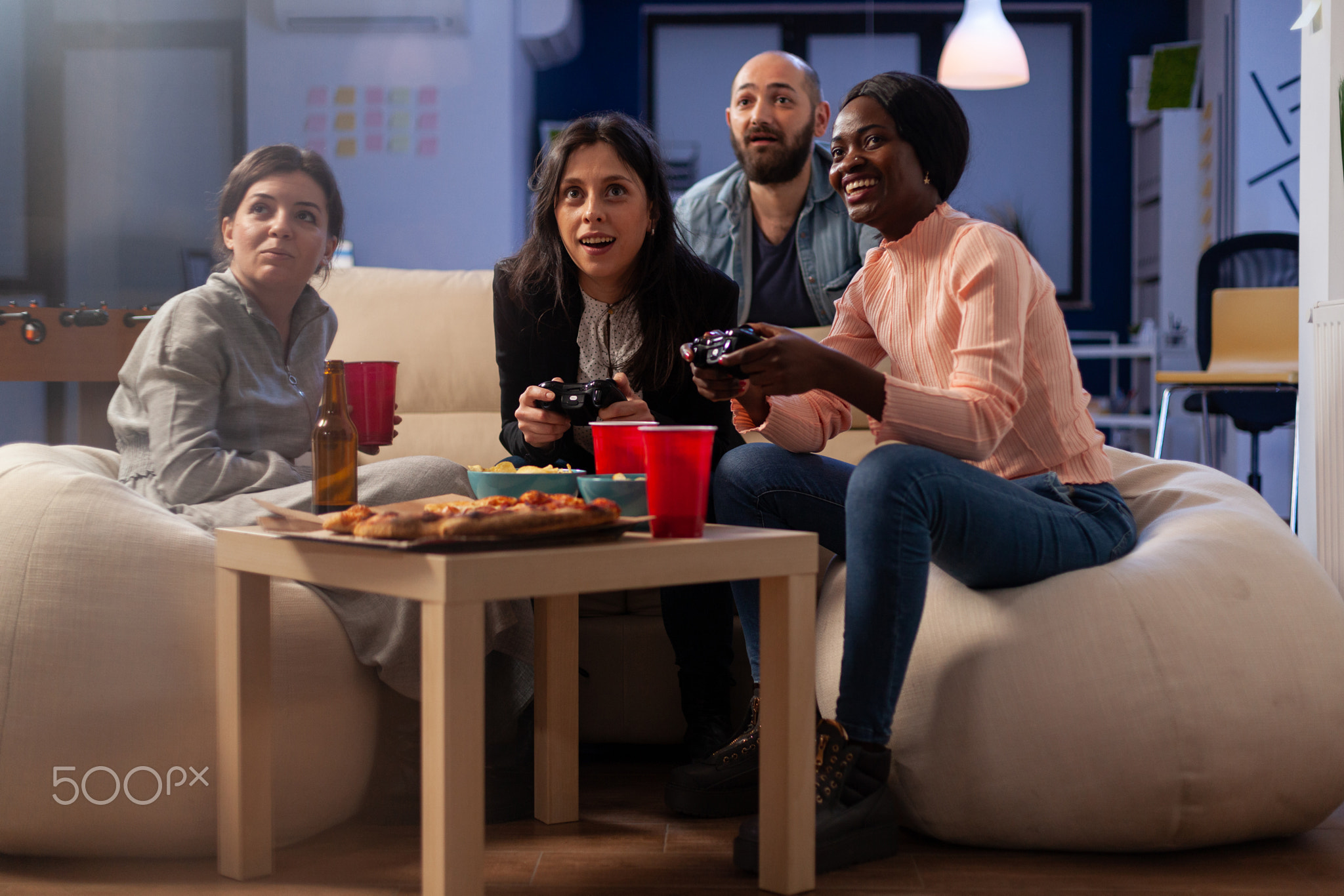 Cheerful workmates using joystick to play online videogames