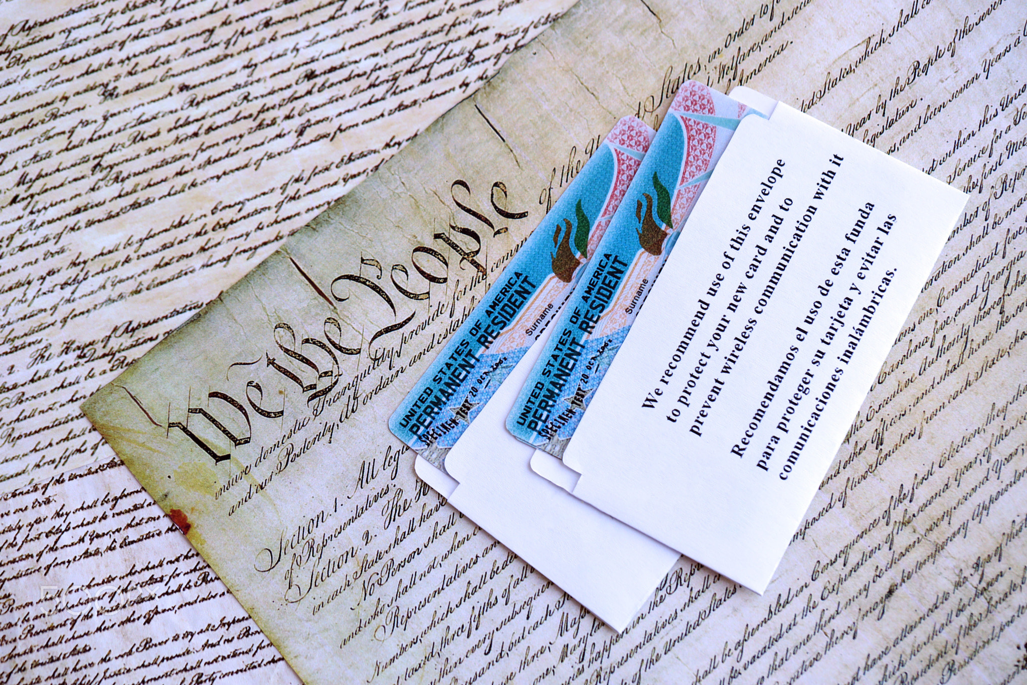Permanent resident green card in envelope lies on US constitution page