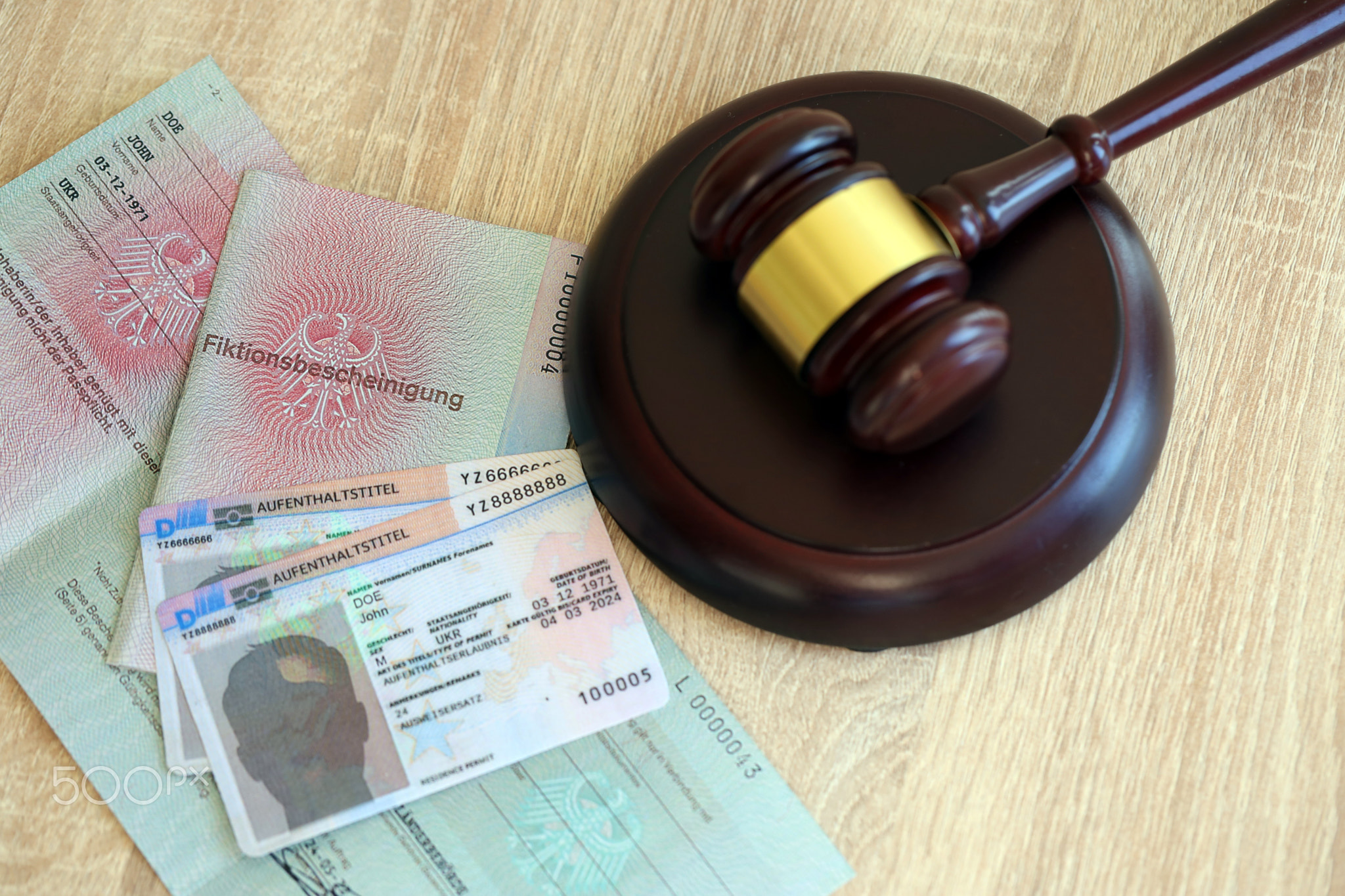 German temporary Permanent resident card lies with judge hammer. Aufenthaltstitel