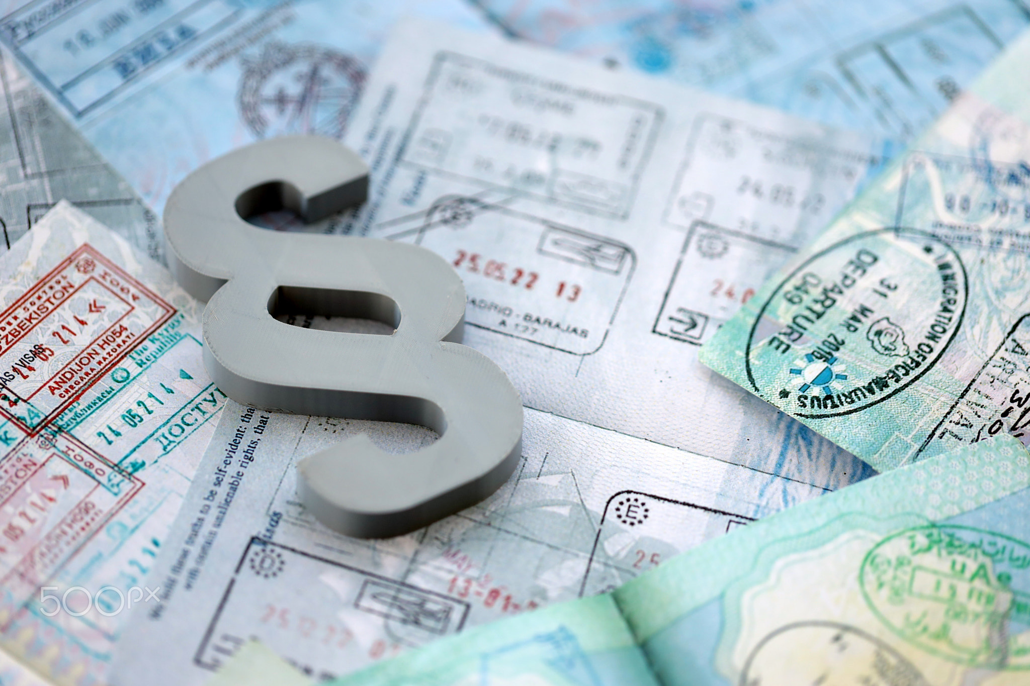 Paragraph symbol on passport pages full of colorful stamps after travel and tourism