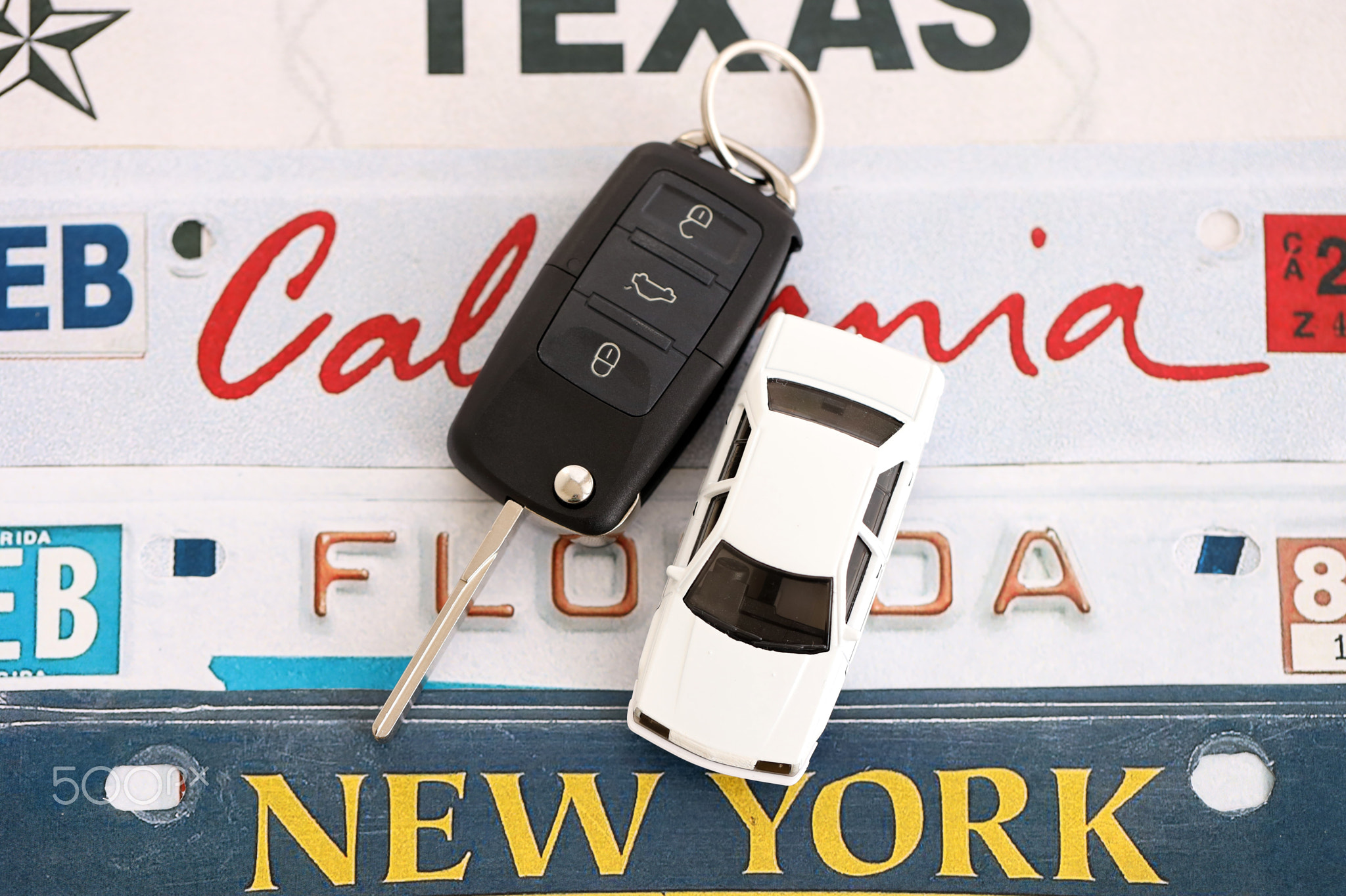 Remote control car keys on US license plates with state names. Driving in United States
