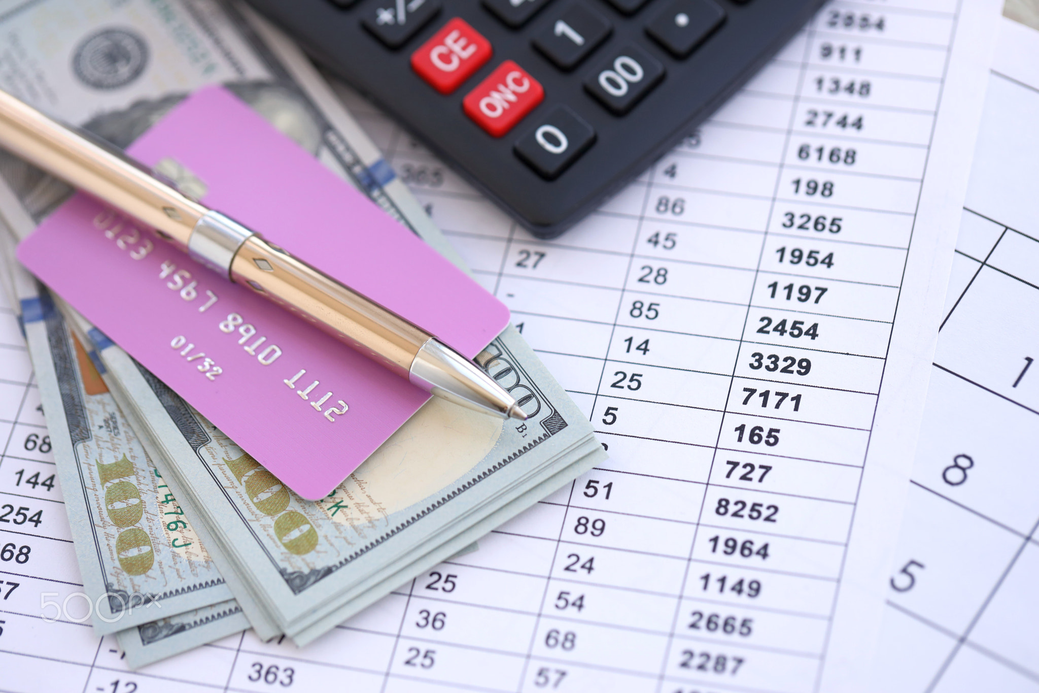 Credit card and pen with US dollar currency money bills banknotes on calculations document