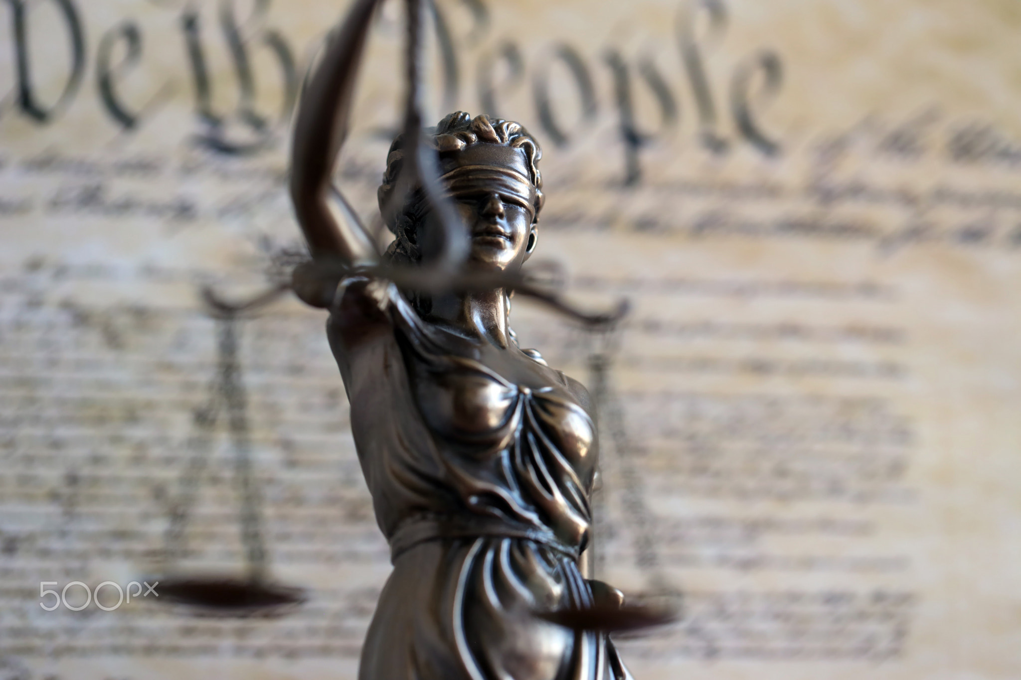 The statue of justice Themis or Justitia, the blindfolded goddess of justice against US Constitution