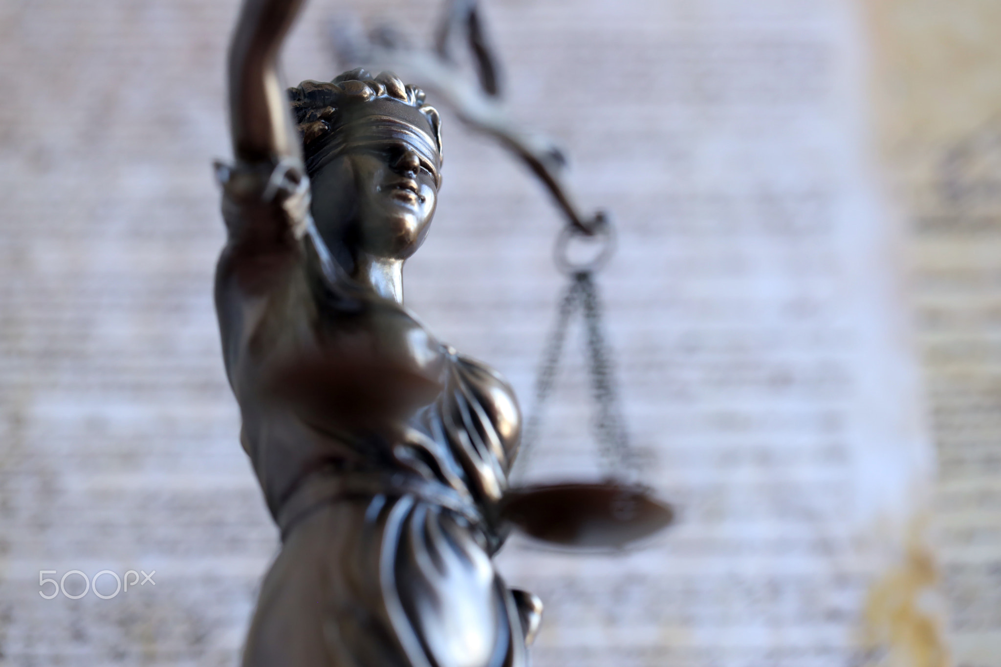 The statue of justice Themis or Justitia, the blindfolded goddess of justice against US Constitution