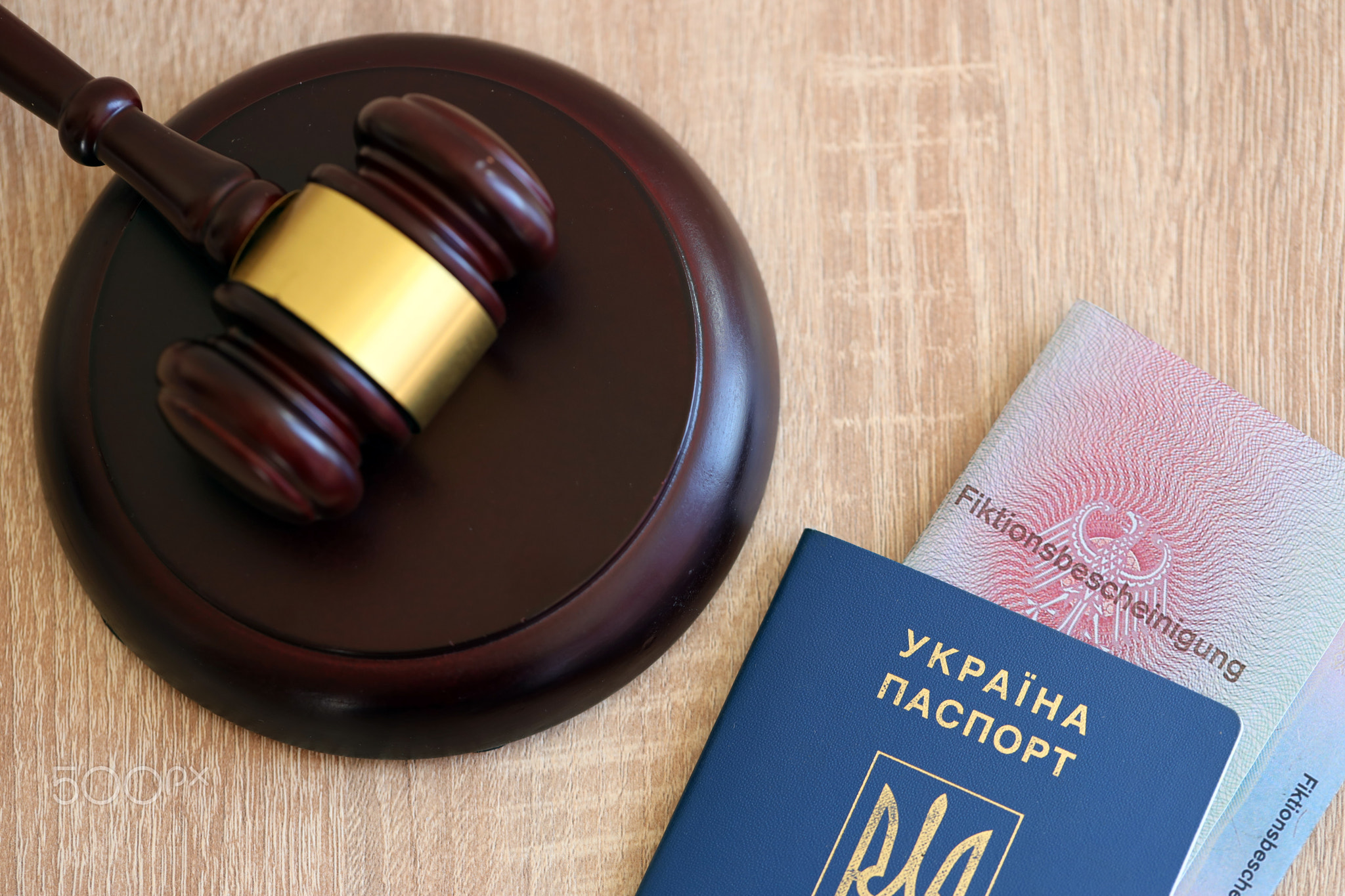 German temporary Permanent resident card and Ukrainian passport lies with judge hammer