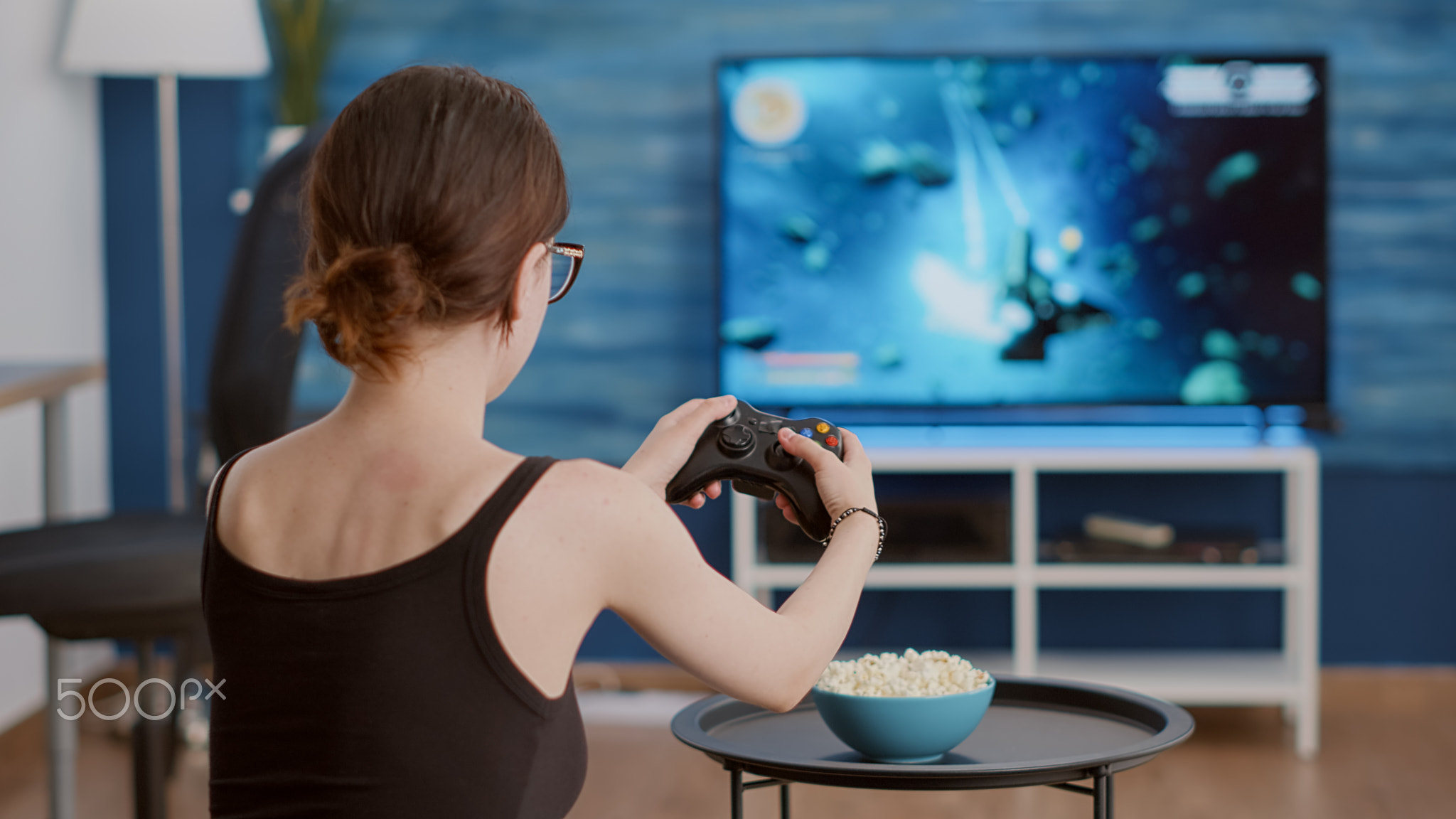 Closeup of woman holding controller celebrating victory in online first person shooter game