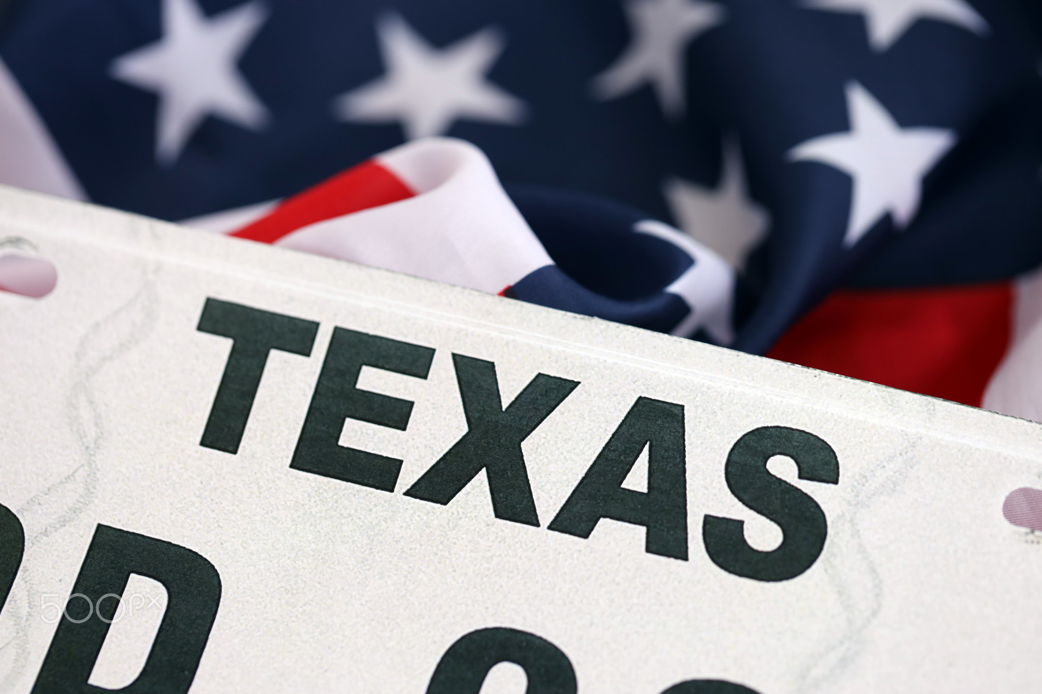 USA state of Texas license plate on US flag. Car driving in Texas