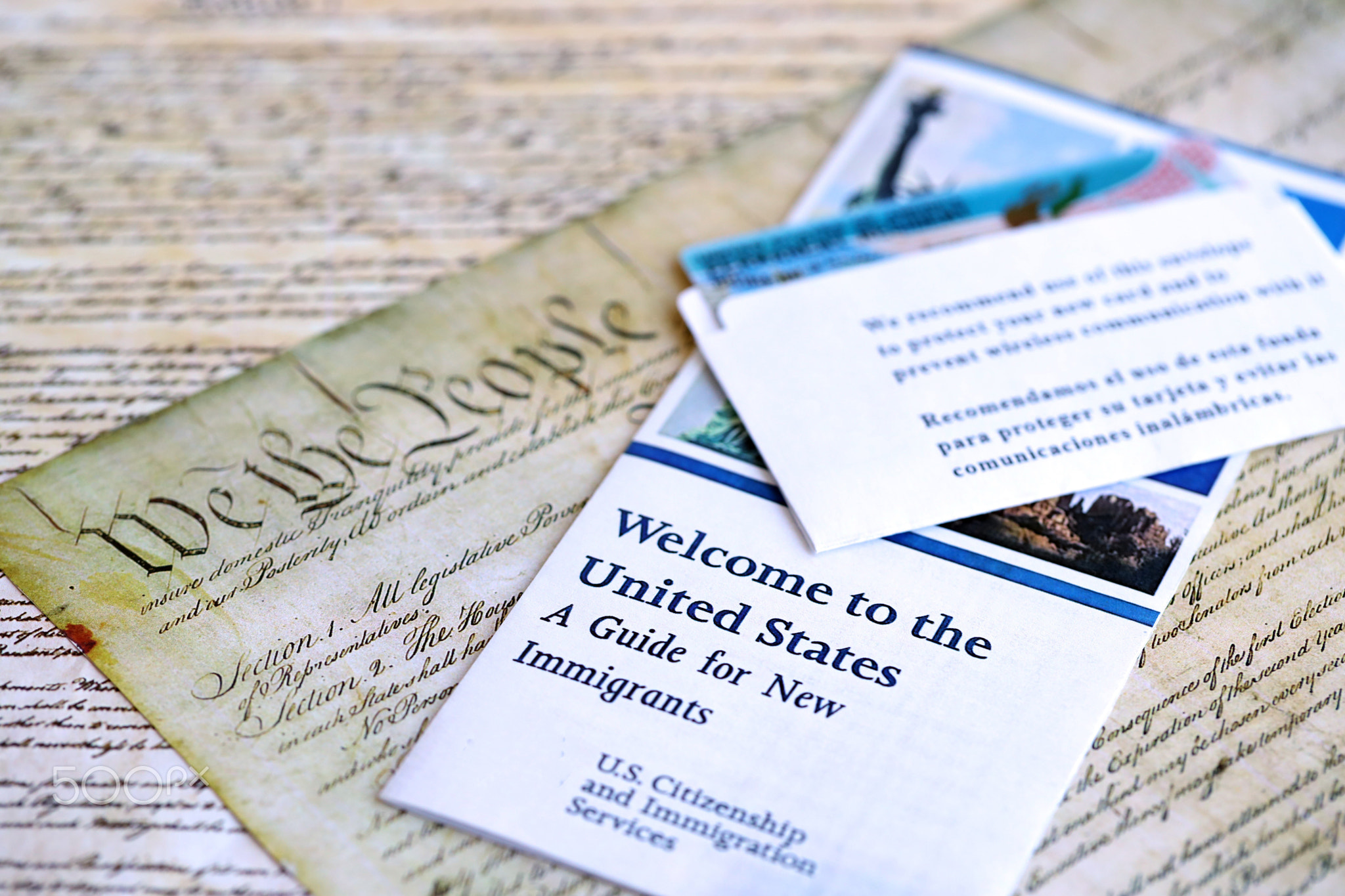 Permanent resident green card in envelope lies on US constitution page
