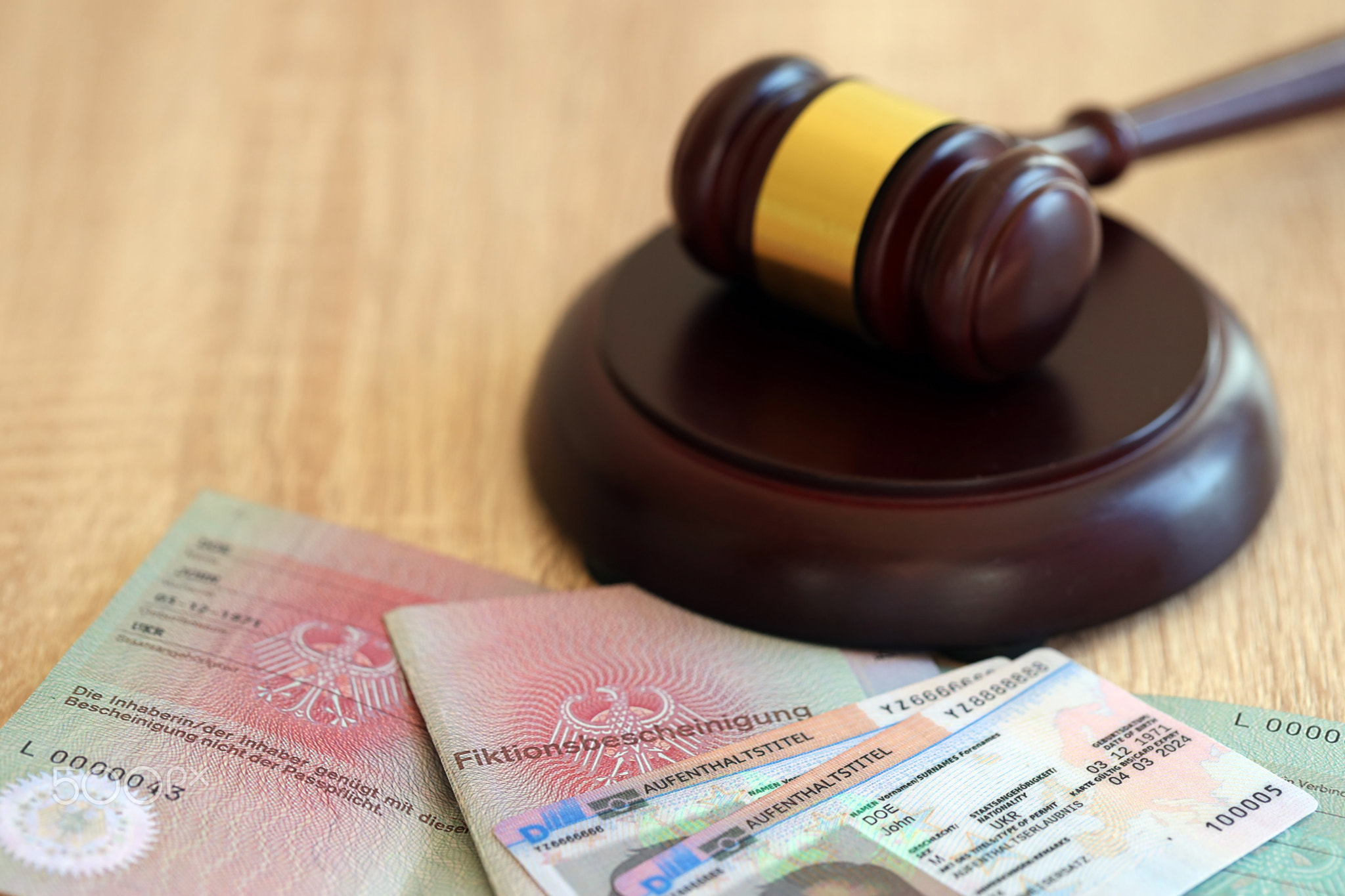 German temporary Permanent resident card lies with judge hammer. Aufenthaltstitel