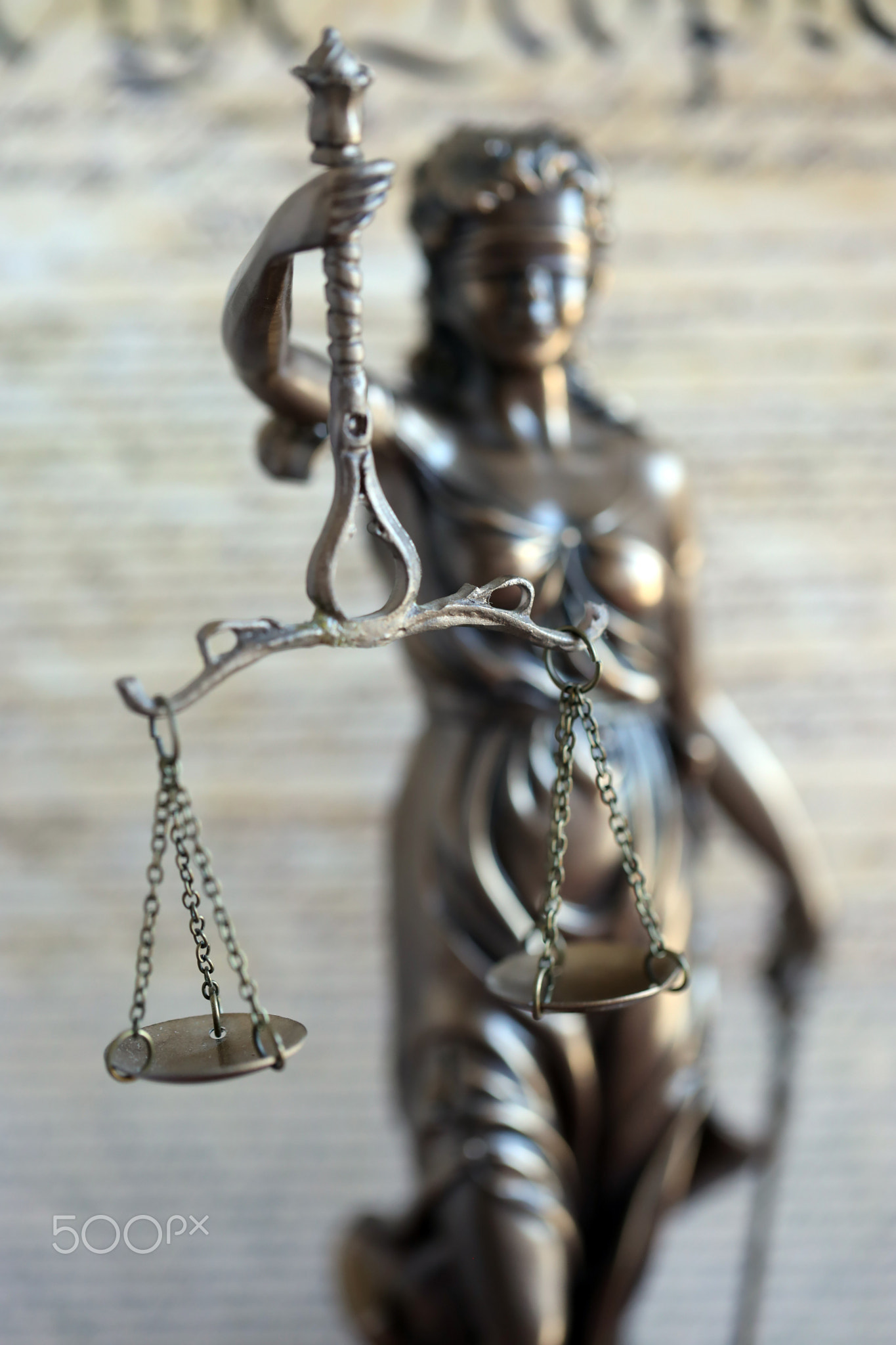 Lady Justice bronze statue and US Constitution blurred page close up. Lawsuit and punishment