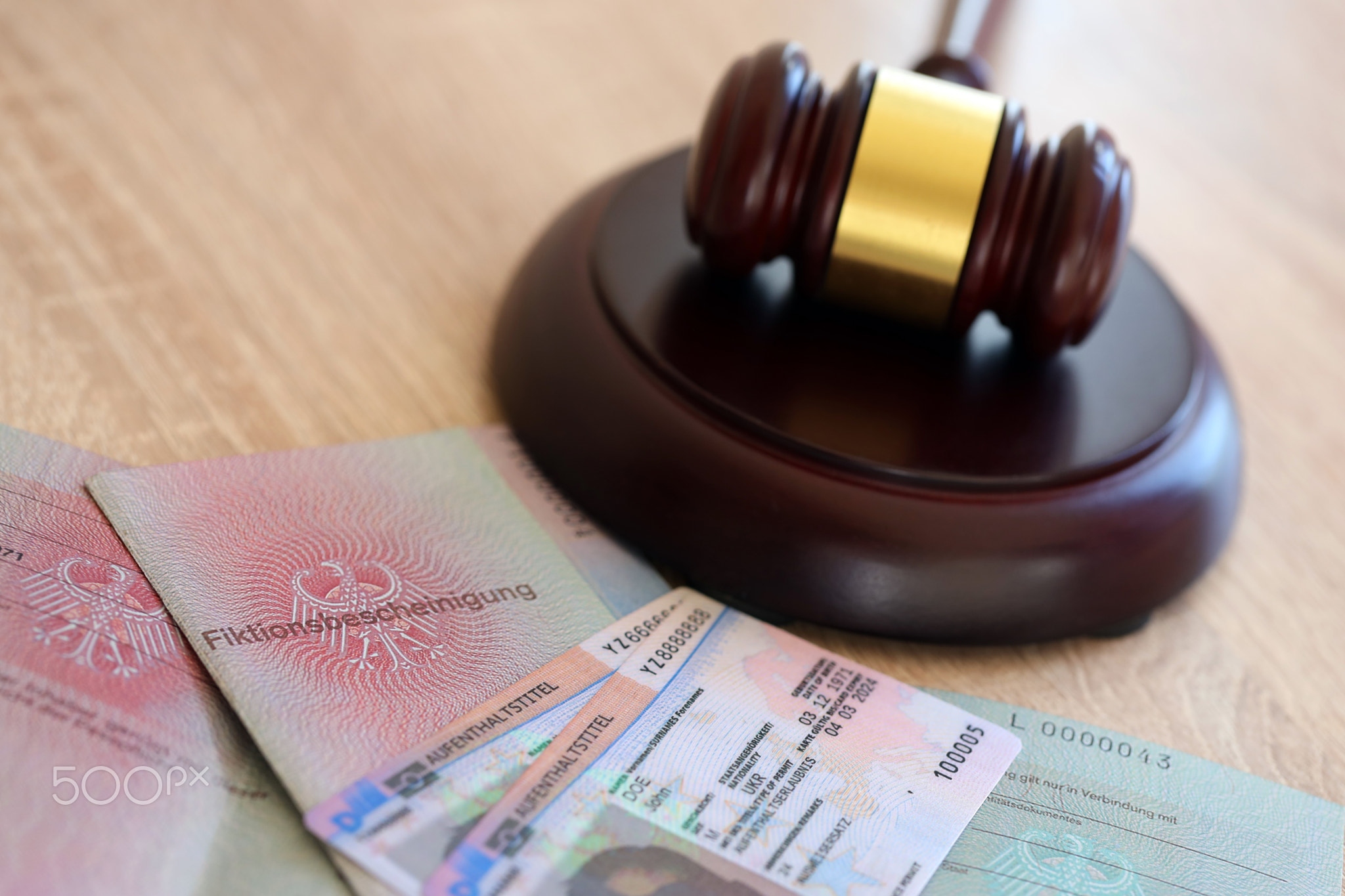 German temporary Permanent resident card lies with judge hammer. Aufenthaltstitel