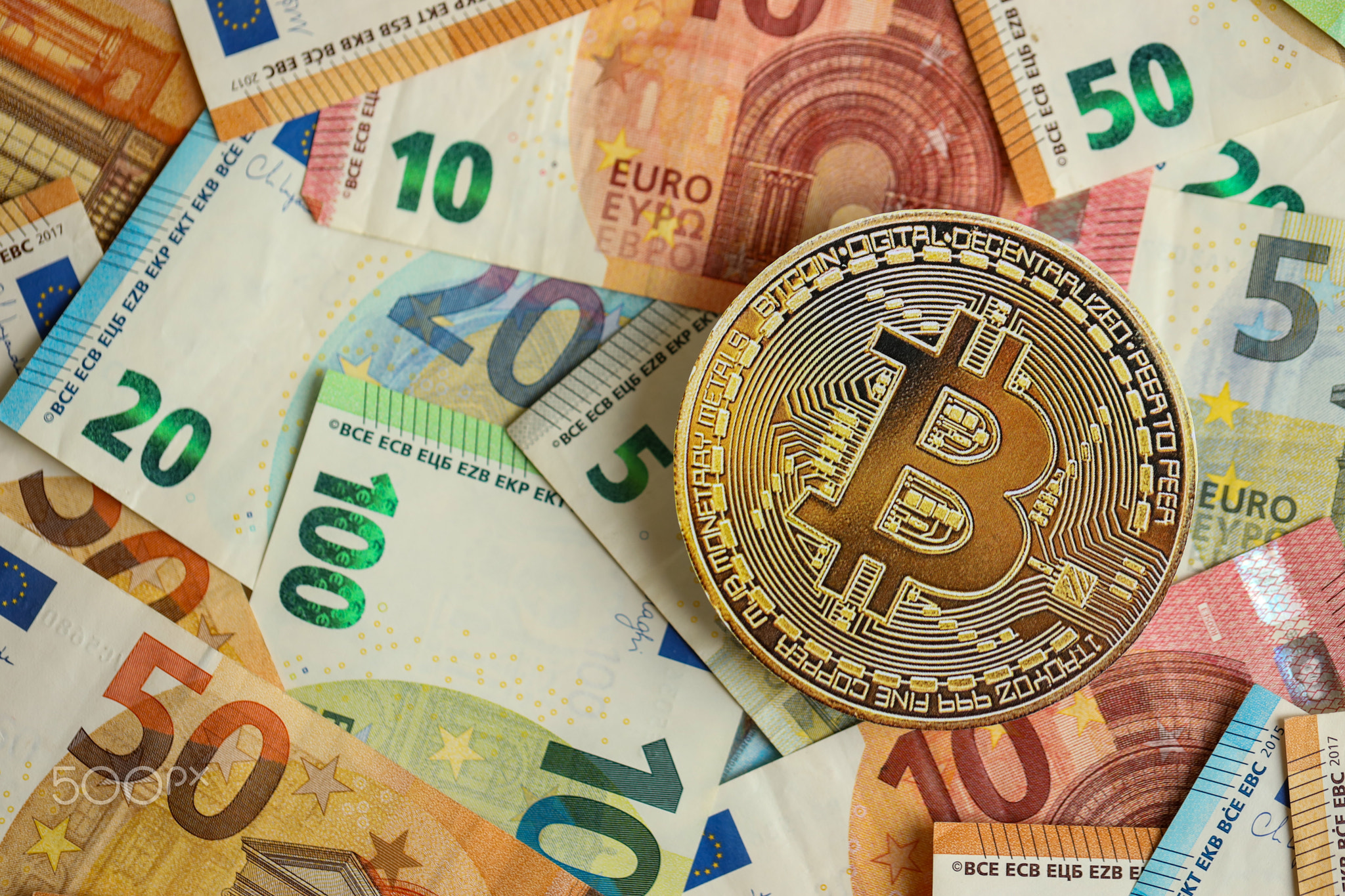 Bitcoin BTC coin with big amount of european euro bills