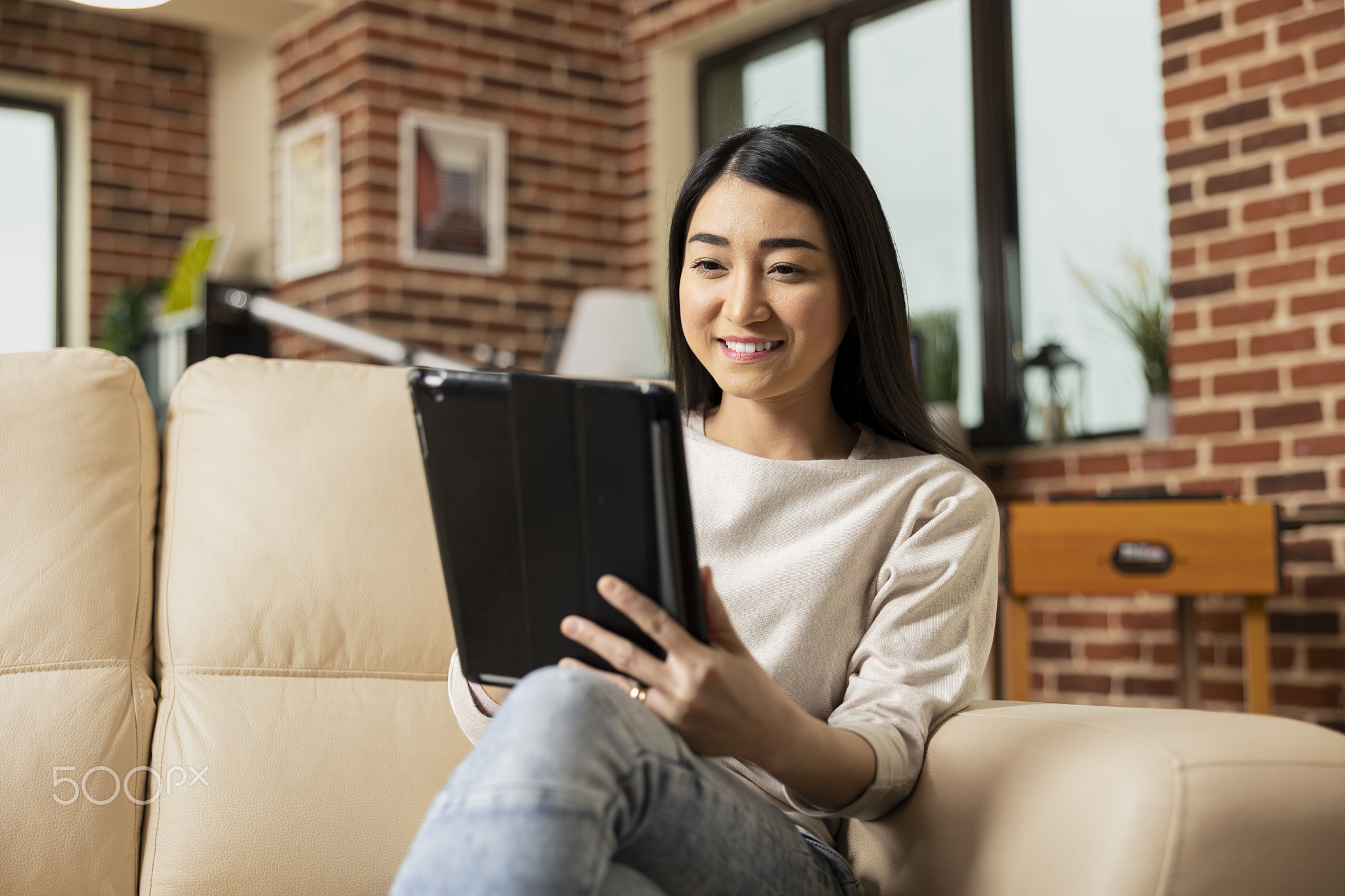 Positive businesswoman reading online articles on tablet