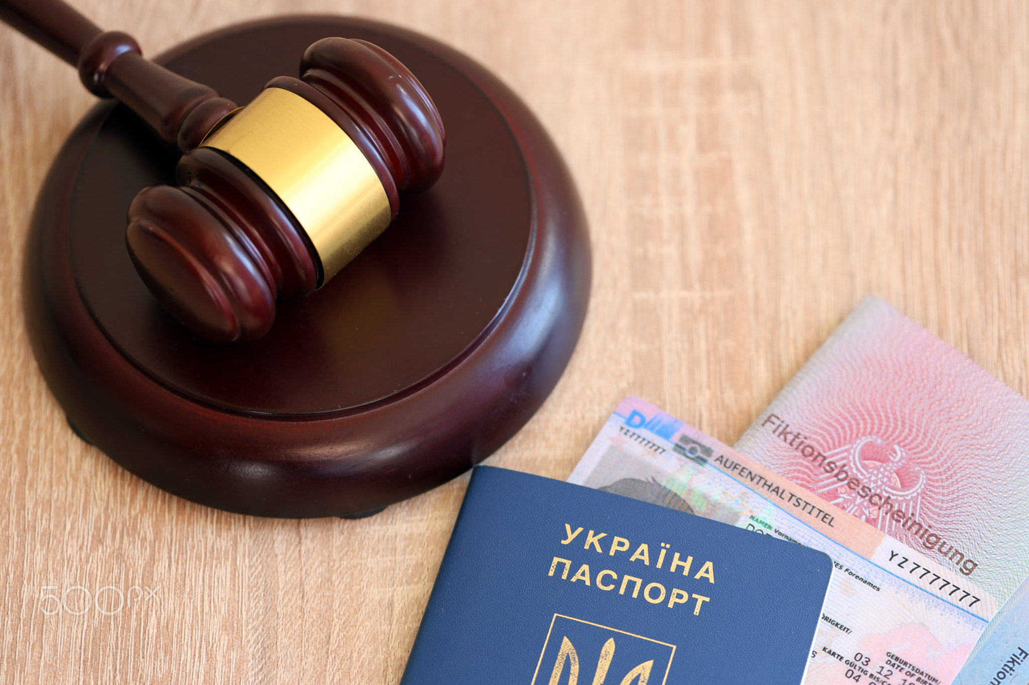 German temporary Permanent resident card and Ukrainian passport lies with judge hammer