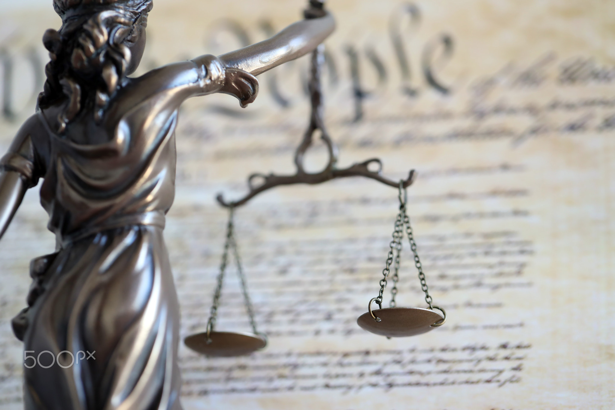 The statue of justice Themis or Justitia, the blindfolded goddess of justice against US Constitution