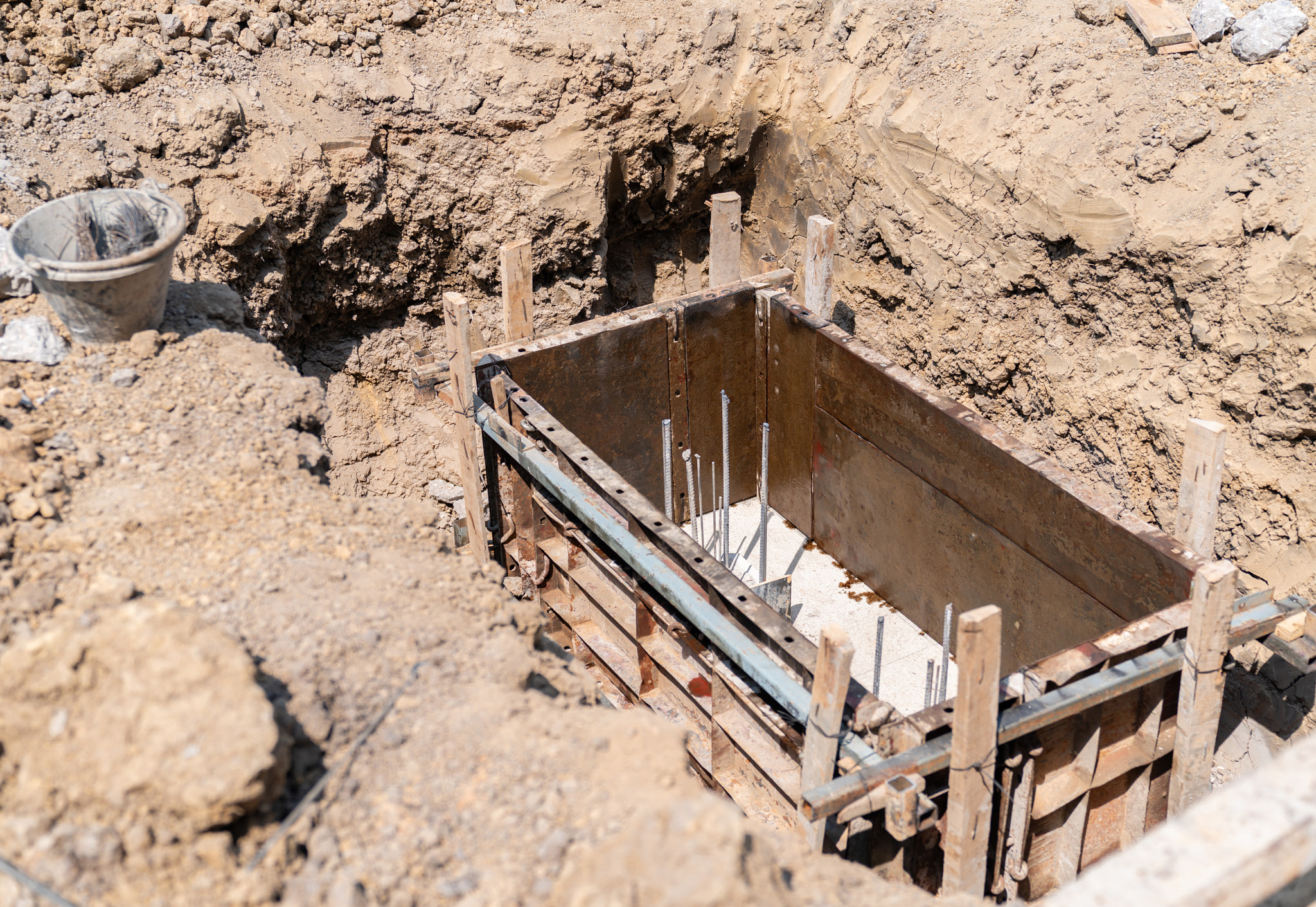 An empty metal framework structure prepared for pouring a concrete foundation inside a deep earth ex