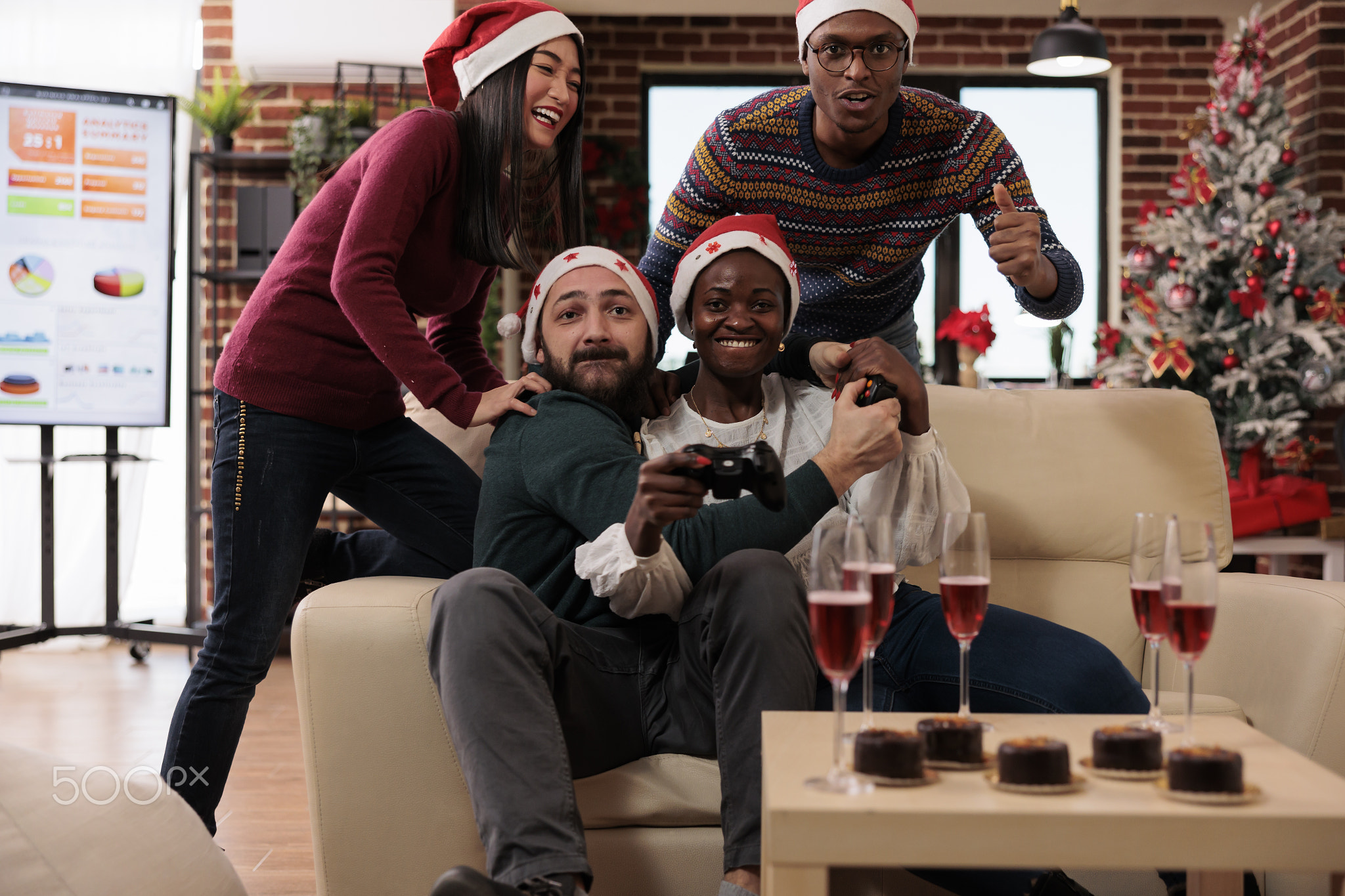 Happy coworkers having fun with video games at event