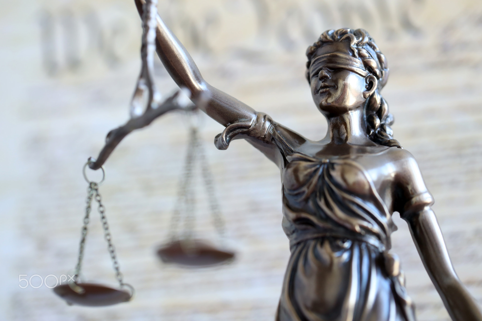 Lady Justice statue with scales on background of US Constitution. Lawsuit and punishment in US