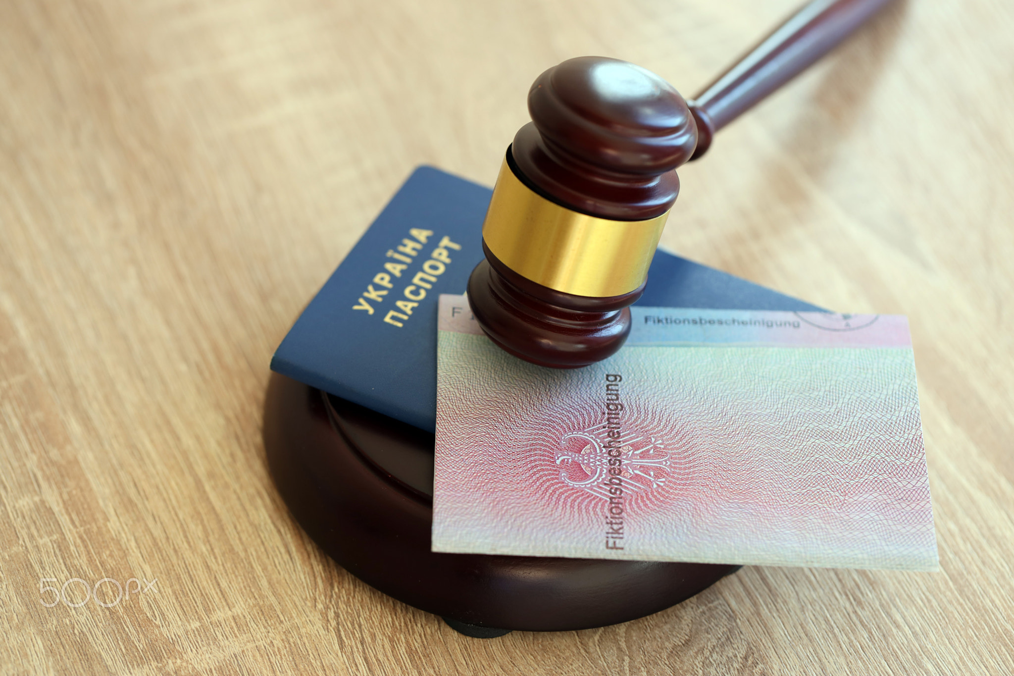German temporary Permanent resident card and Ukrainian passport lies with judge hammer