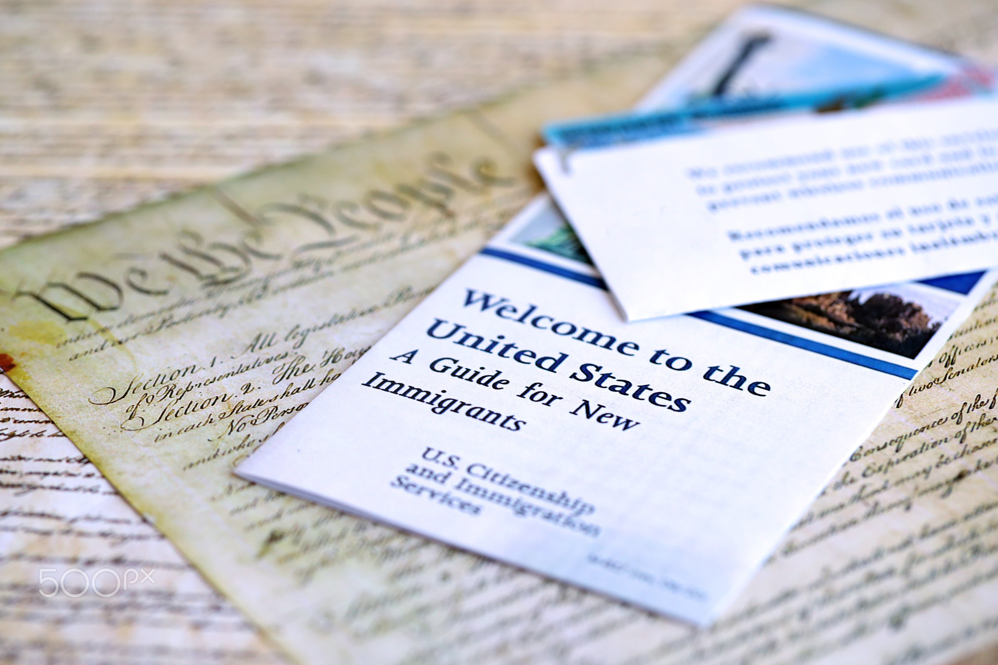Permanent resident green card in envelope lies on US constitution page