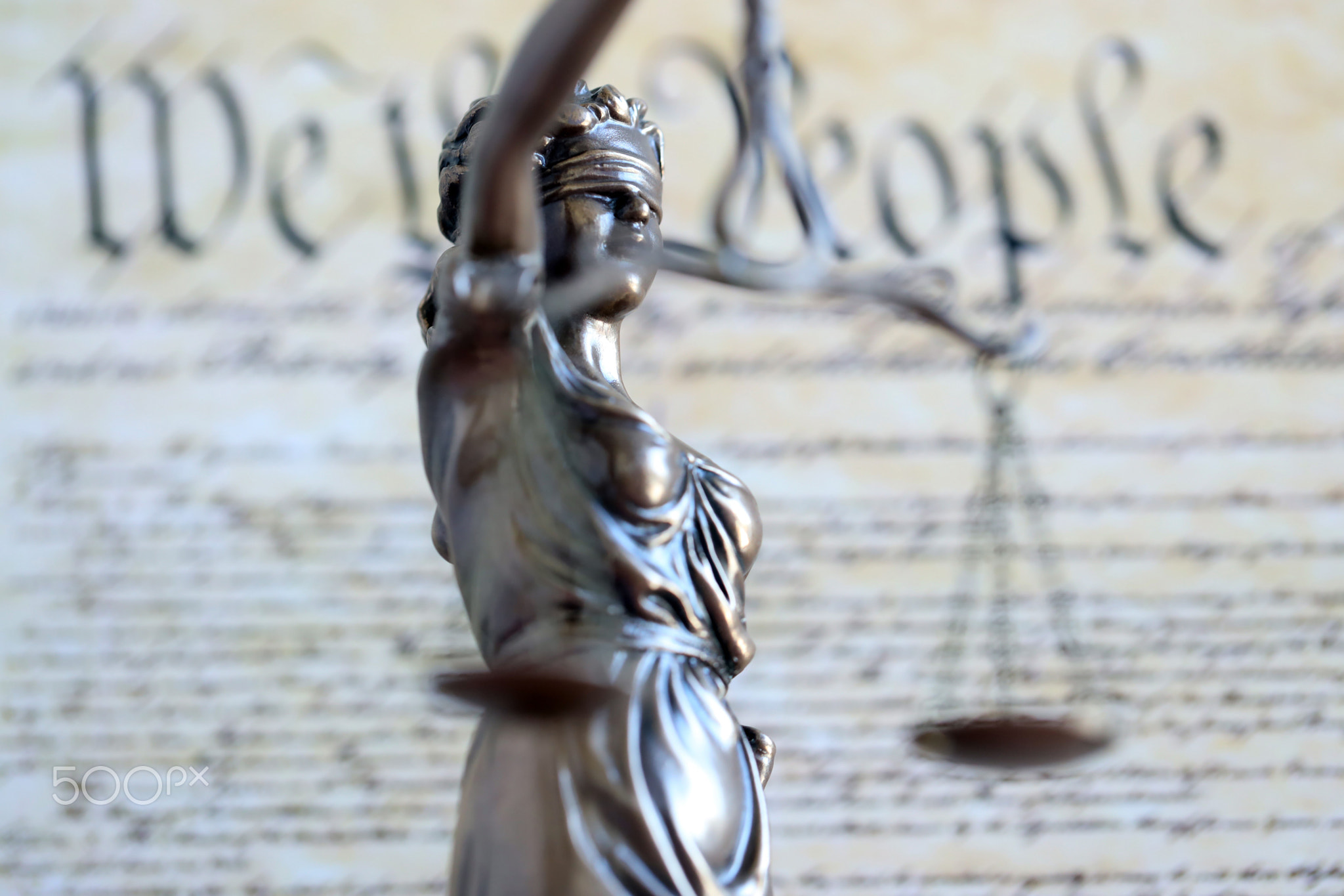 The statue of justice Themis or Justitia, the blindfolded goddess of justice against US Constitution